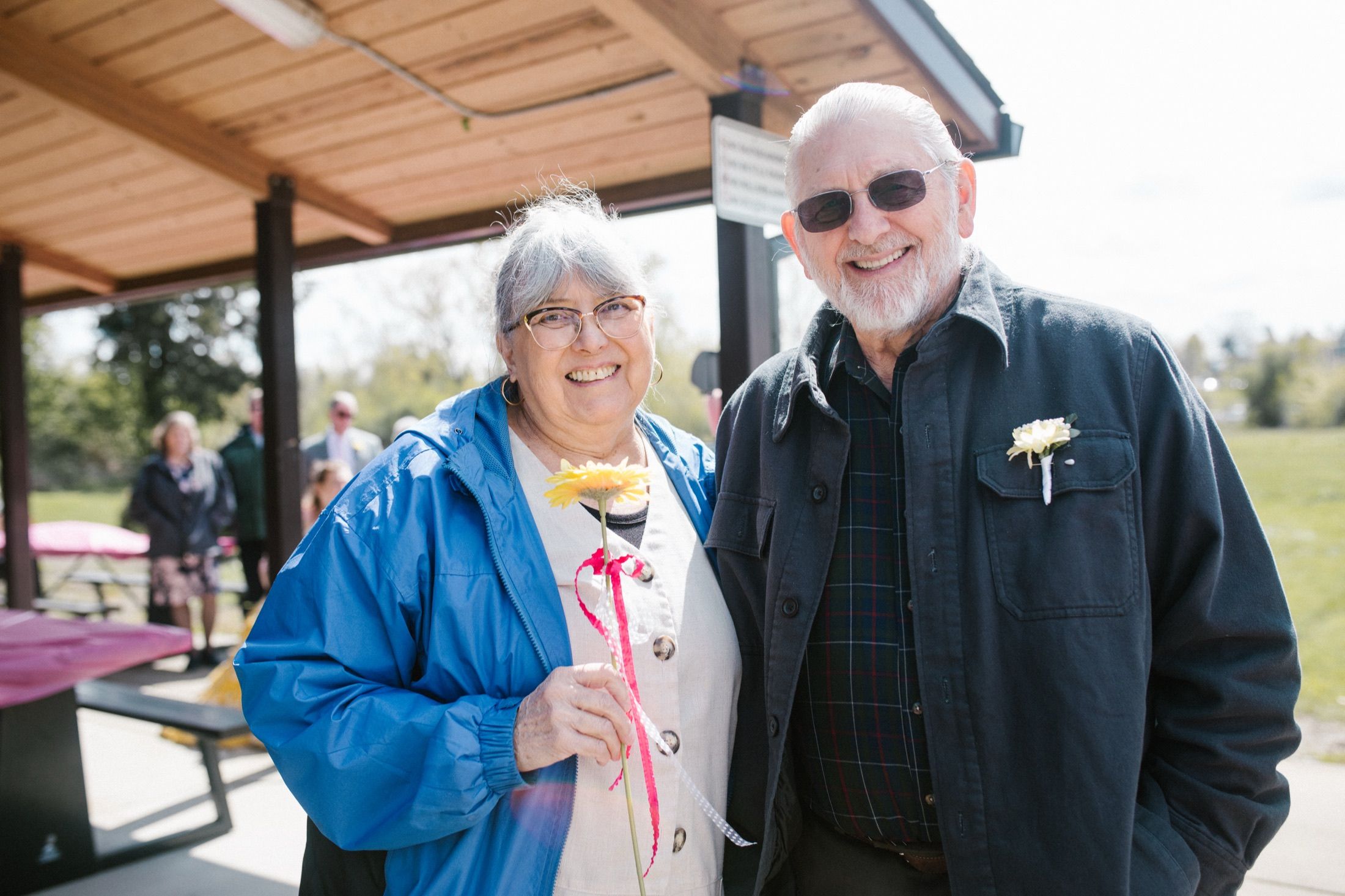 Marilynn and Larry on their wedding day, smiling under the park pavilion.