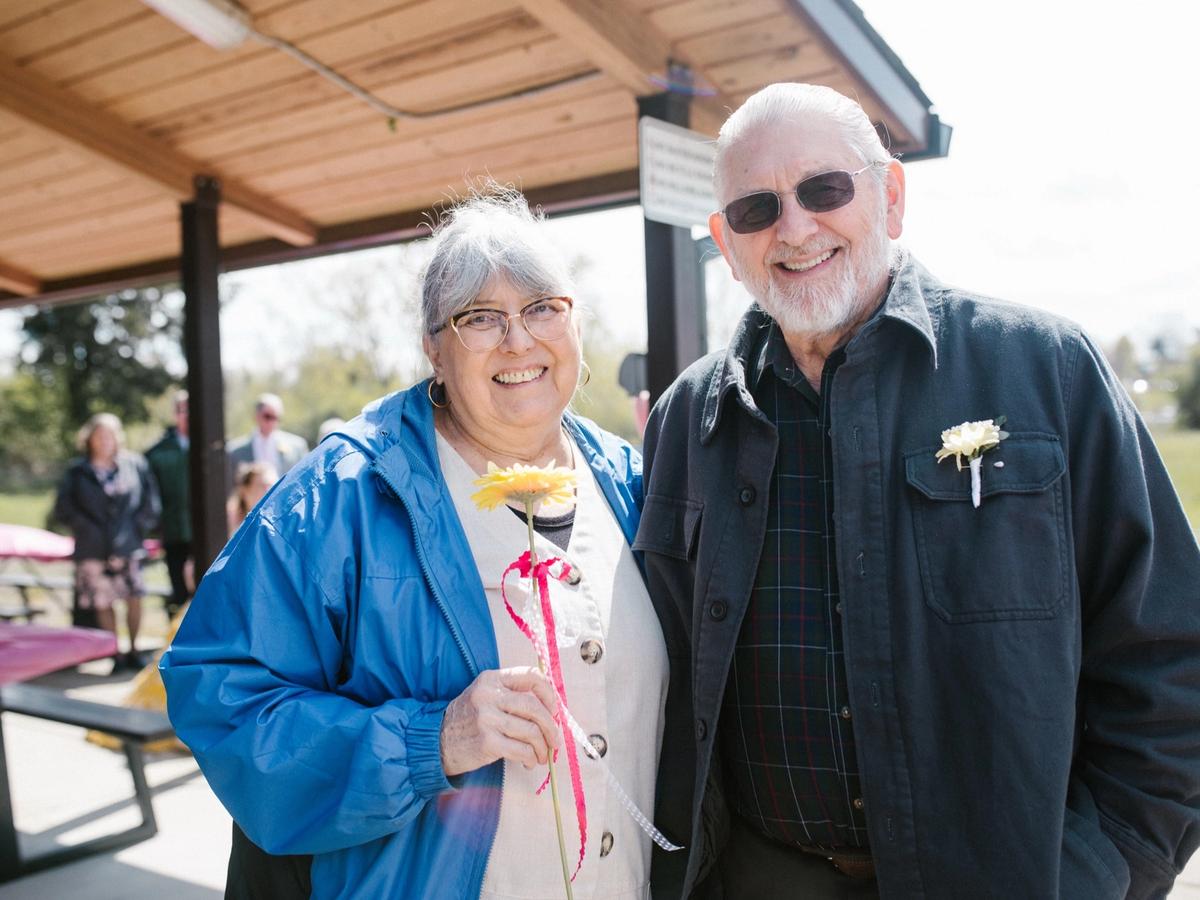 Marilynn and Larry on their wedding day, smiling under the park pavilion.
