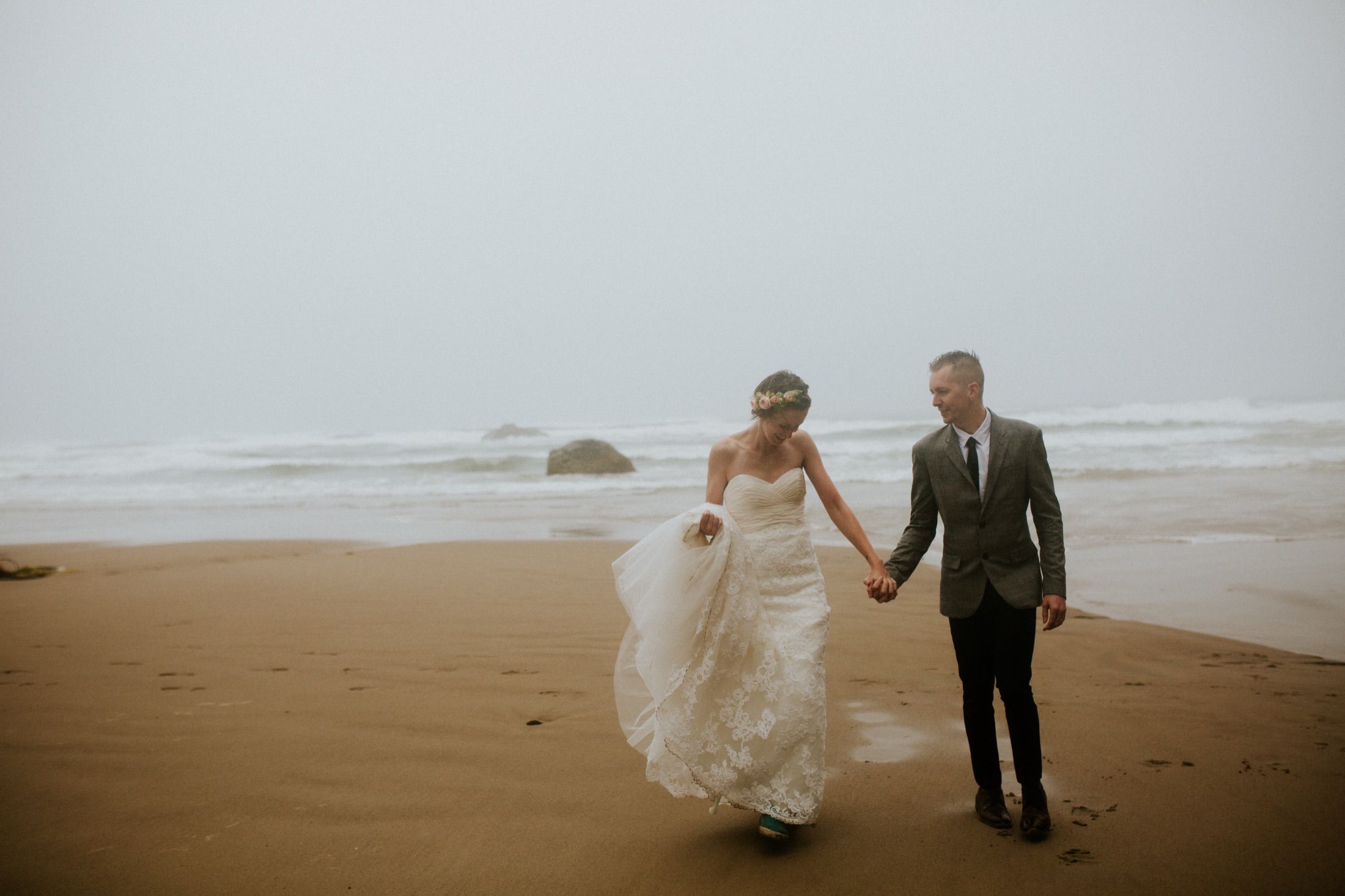 Tasha and Drew walking on a misty Oregon Coast beach.