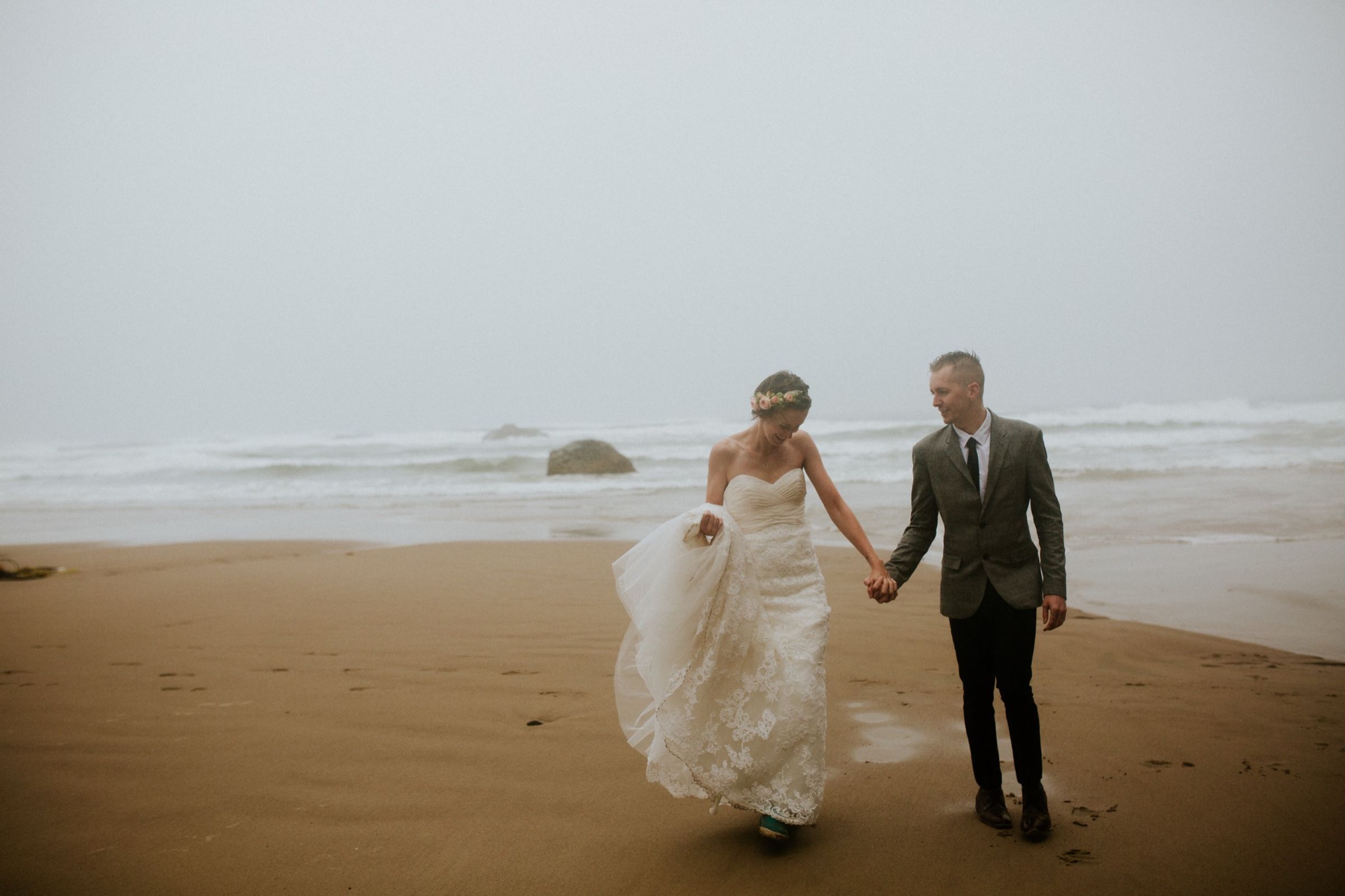 Tasha and Drew walking on a misty Oregon Coast beach.