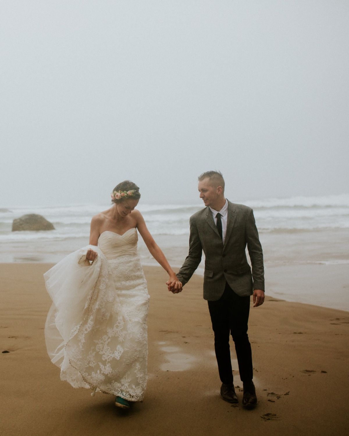 Tasha and Drew walking on a misty Oregon Coast beach.