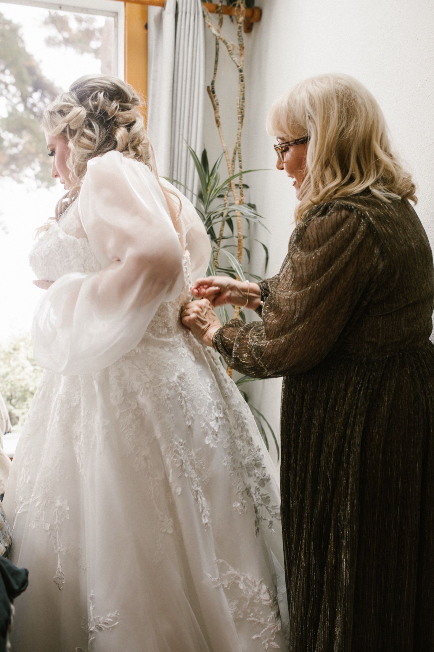 Kenady's mother lacing the back of her wedding dress.