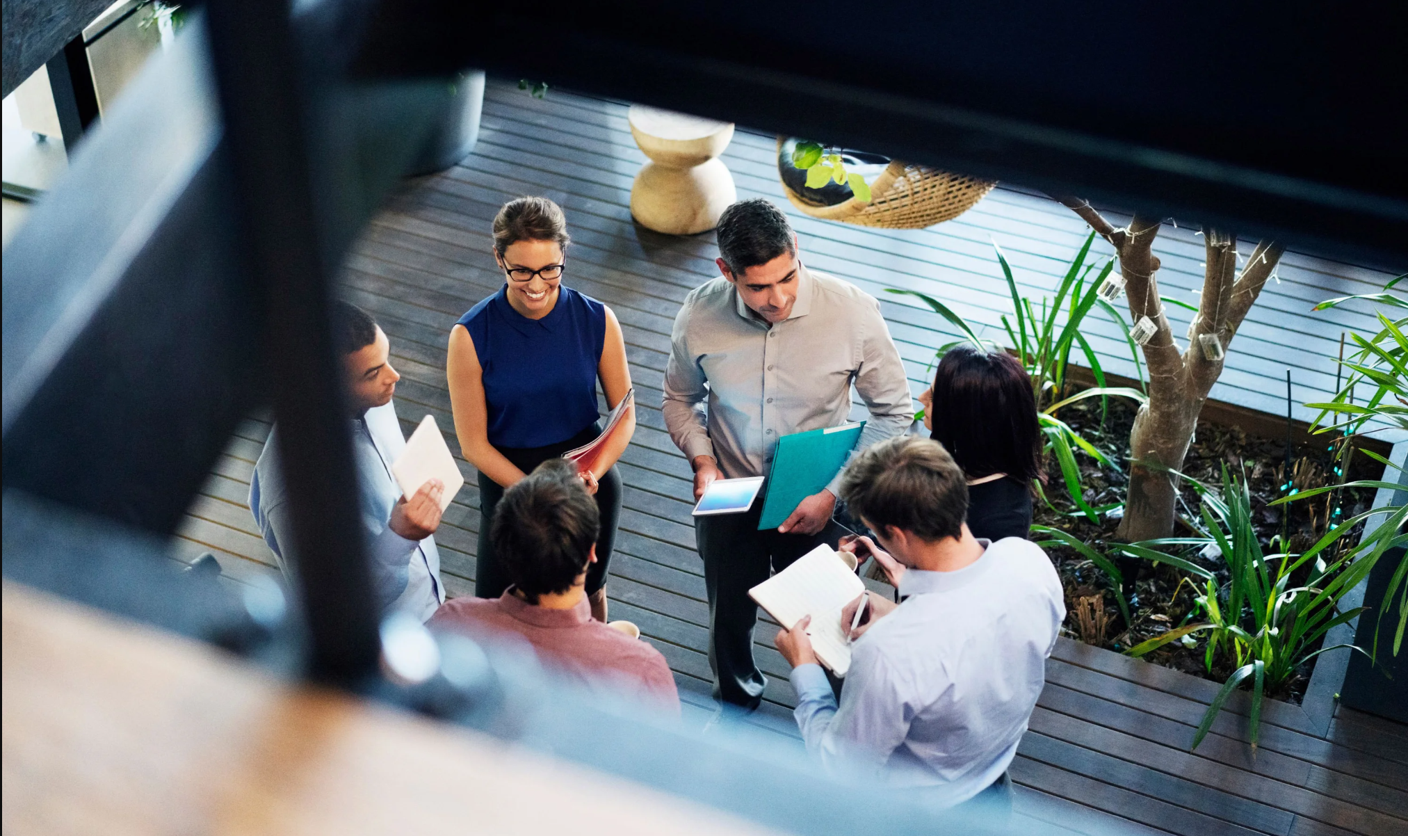 Six people standing in a circle and talking