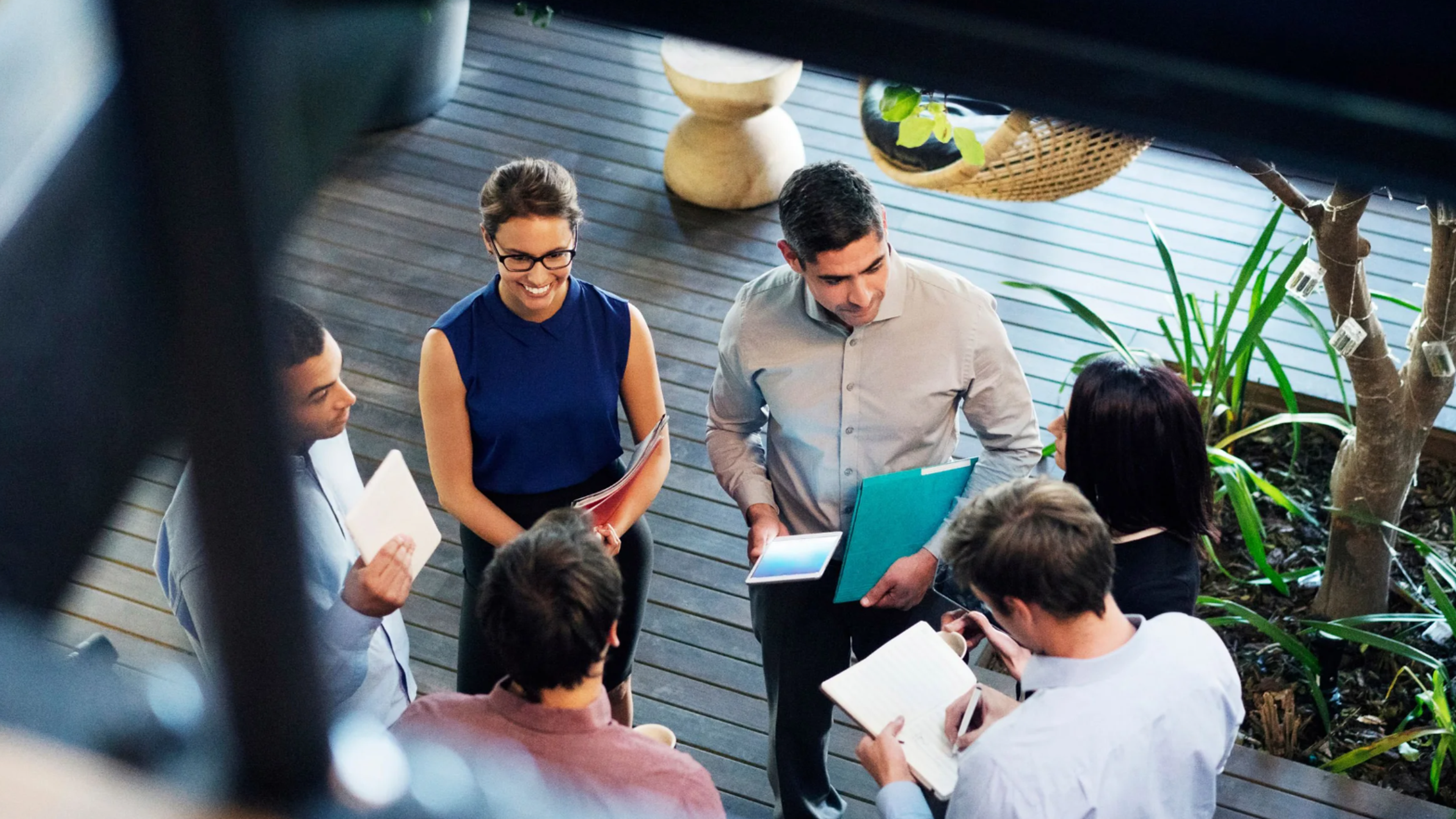 Six people standing in a circle and talking
