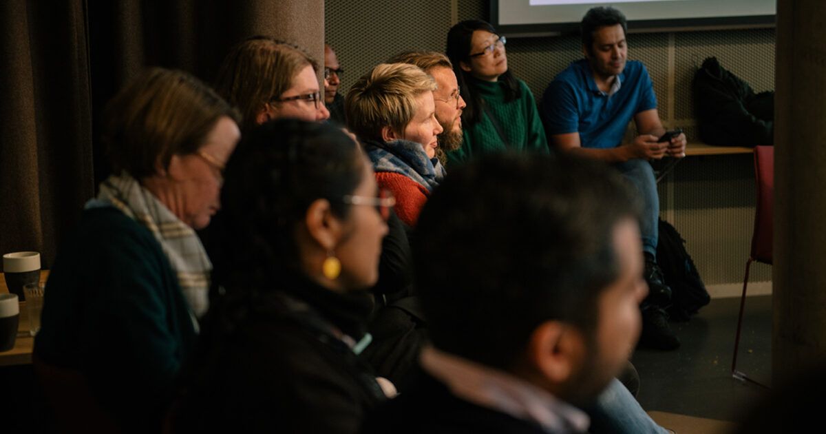 An audience seated in rows listening to a talk