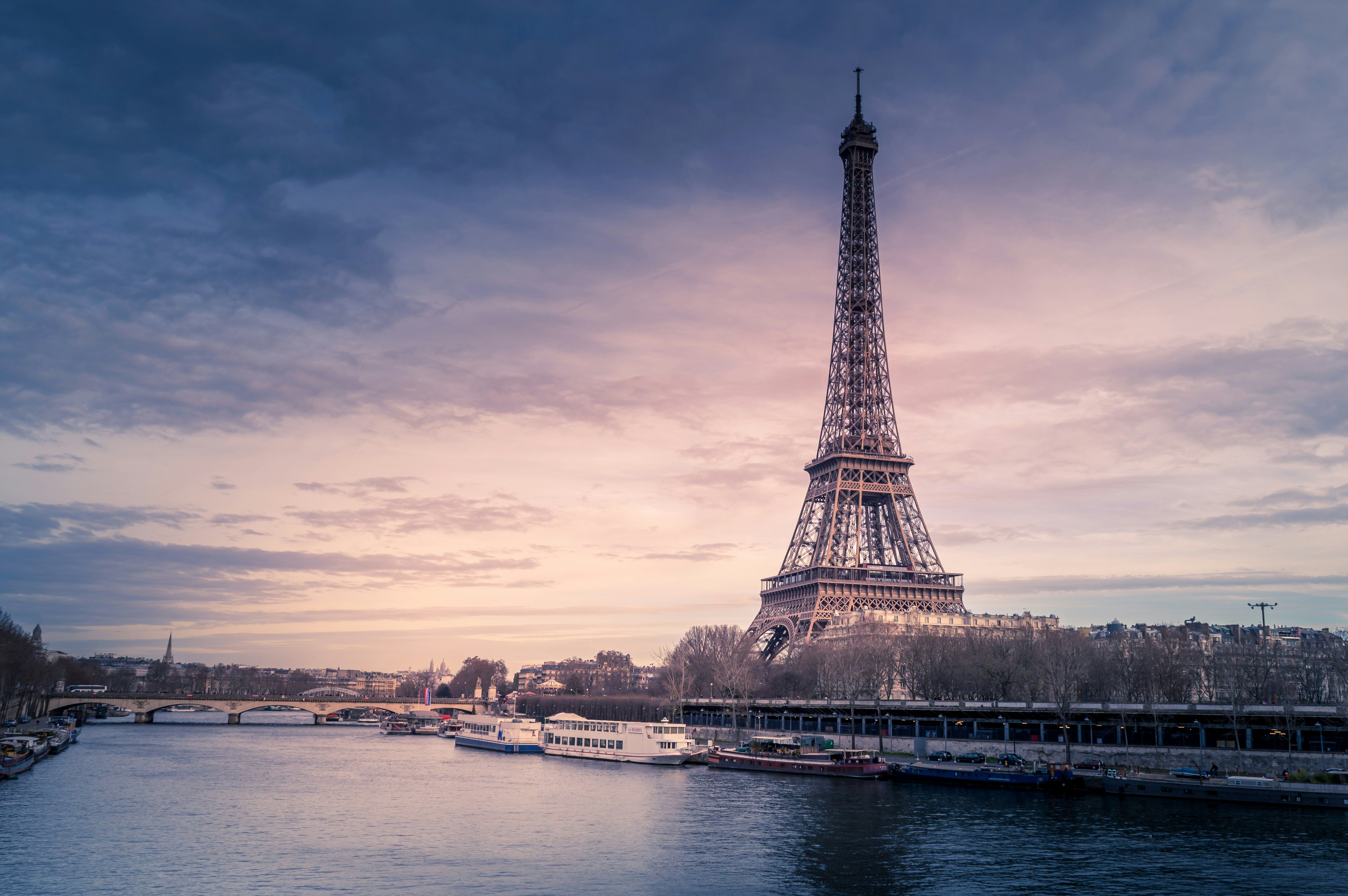 Imagen de la torre eiffel con cielo nublado y con el río a los pies
