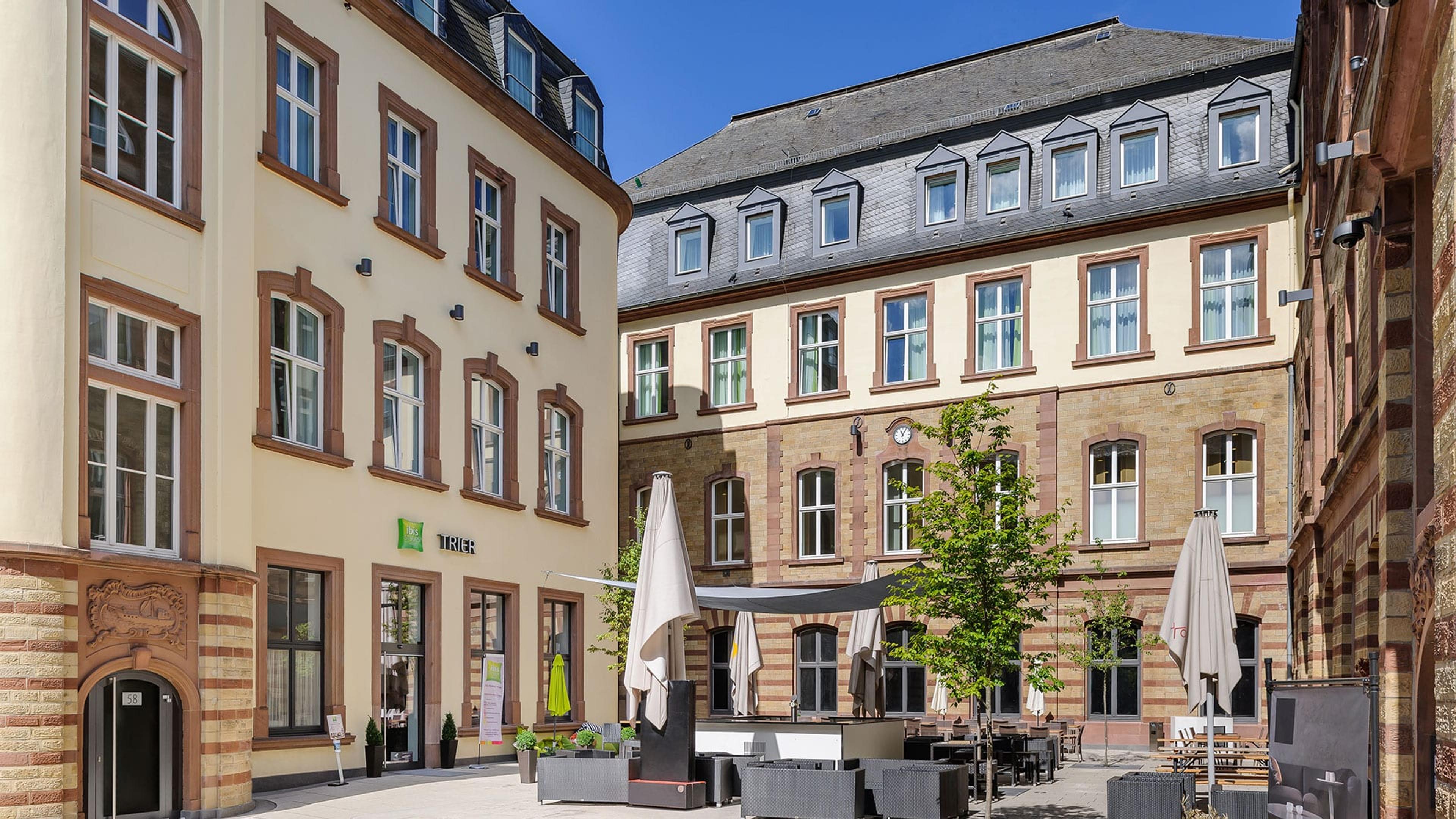 Sandsteinfassade des historischen Posthofs mit ibis Styles Logo