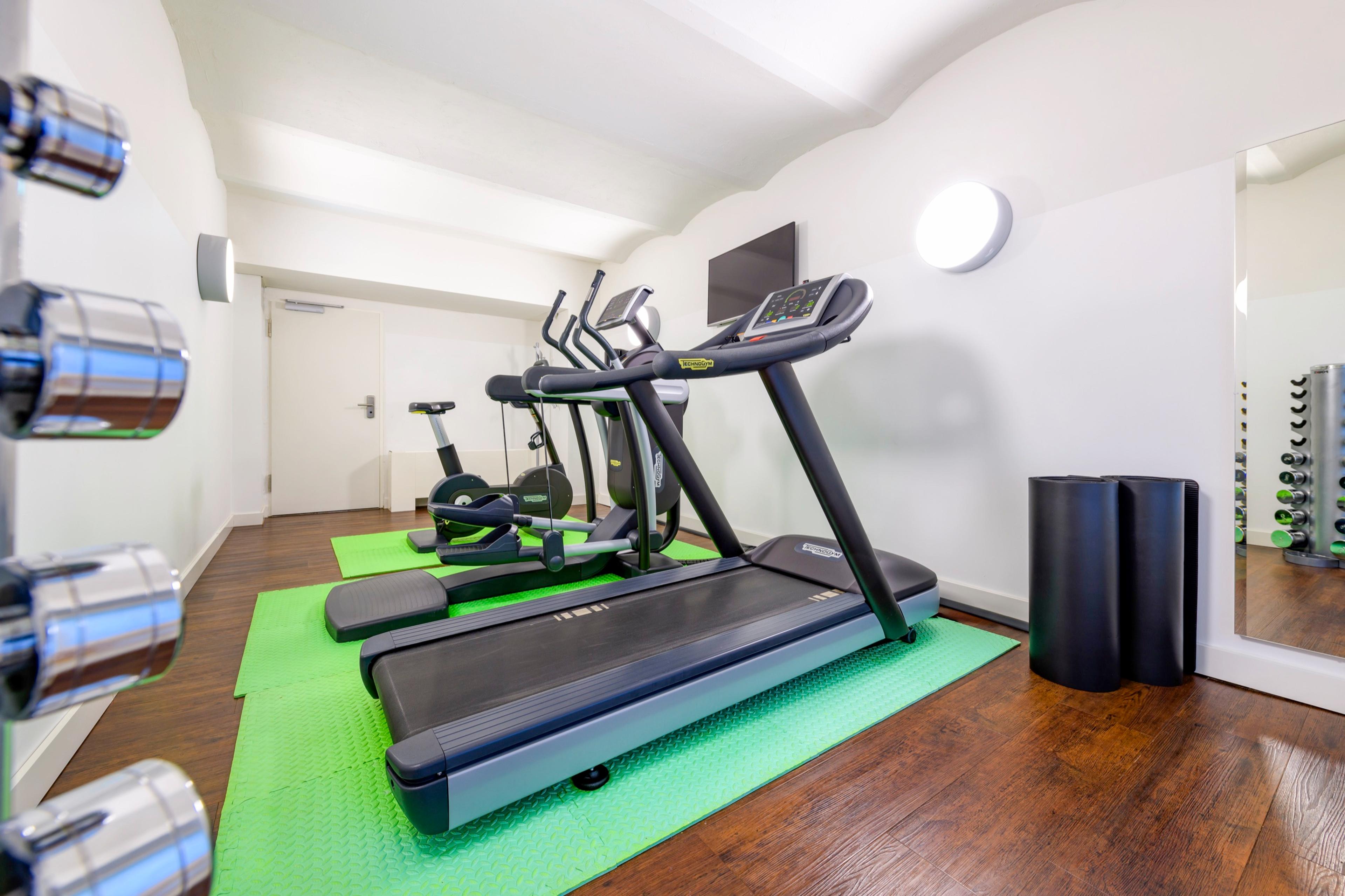 Fitnessbereich mit Laufband, Crosstrainer und Kurzhantel-Rack