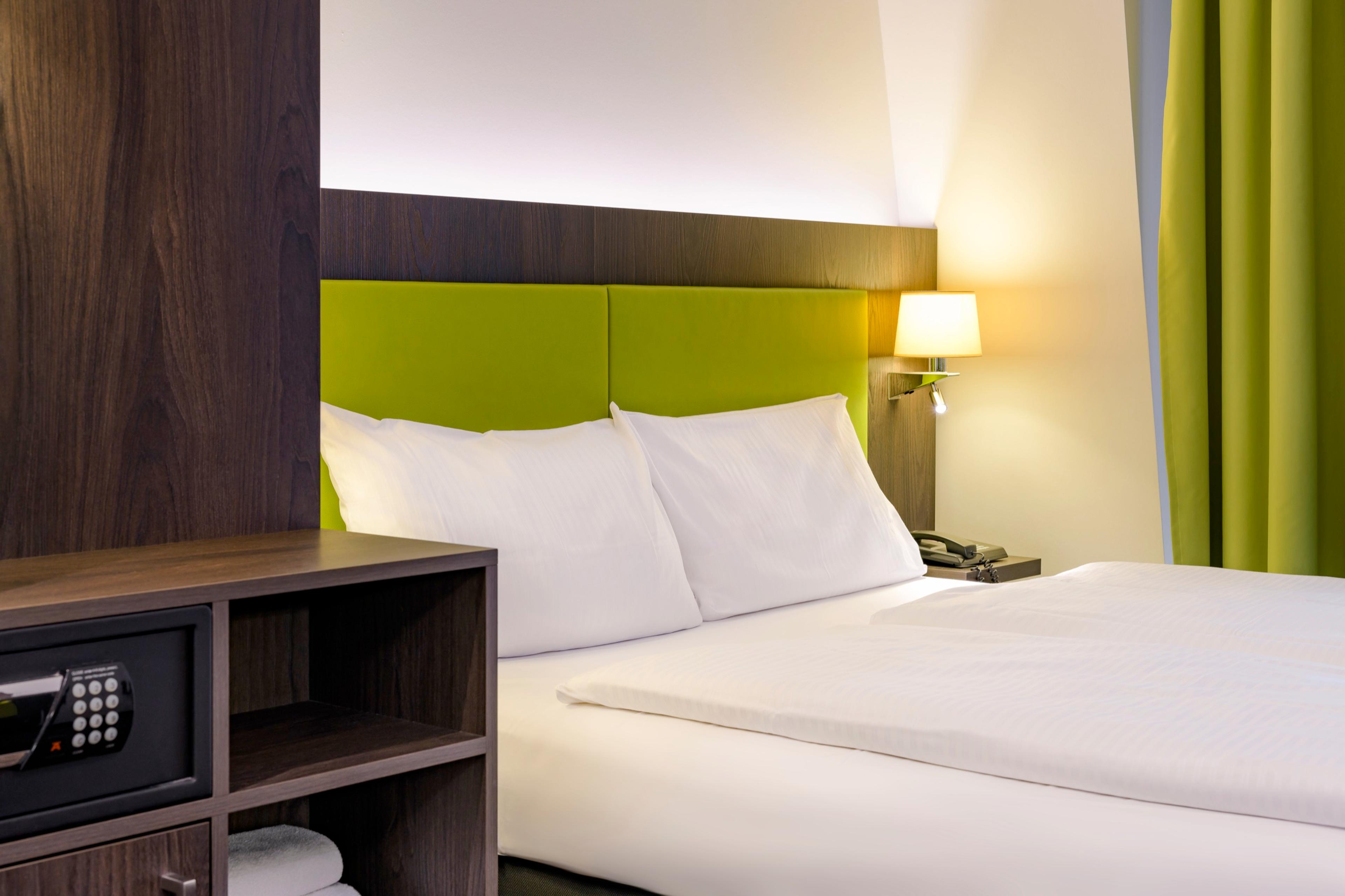 Comfort-Zimmer, Detail mit Kopfteil, Leselampe und Safe