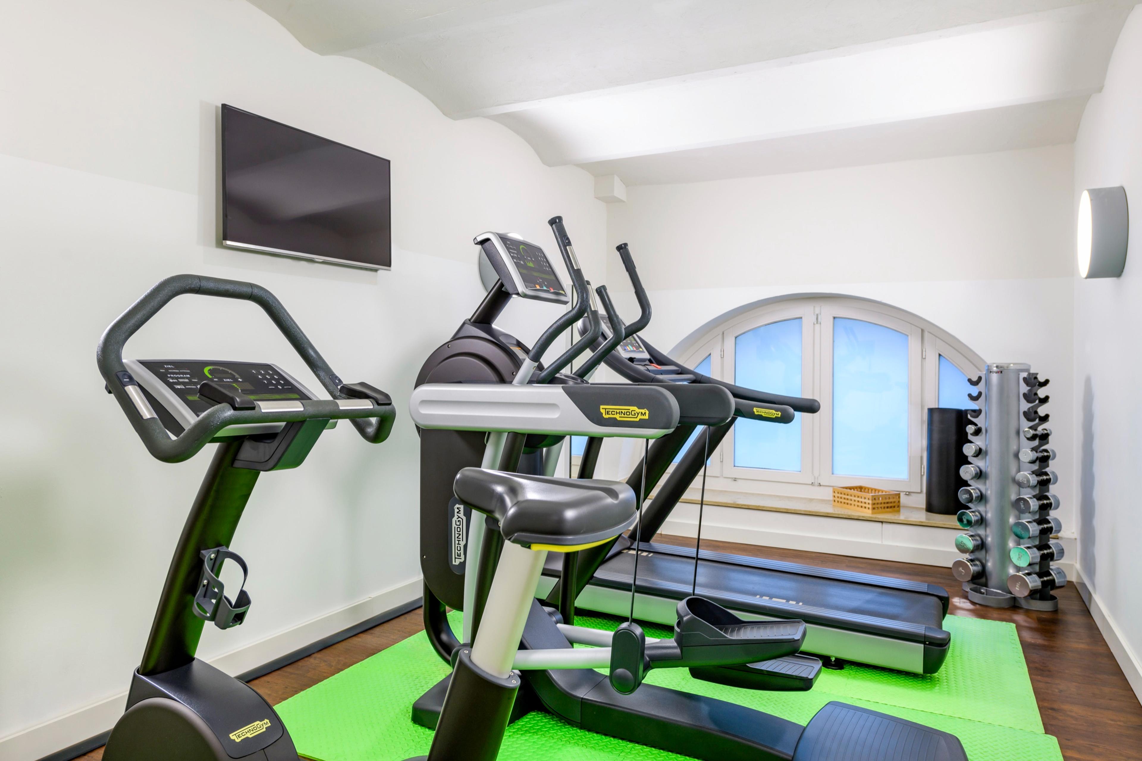 Fitnessbereich mit Technogym-Geräten und Hanteln