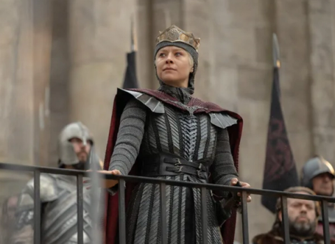 Rhaenyra in mail and a crown standing at a railing above the sept steps, guards on either side of her