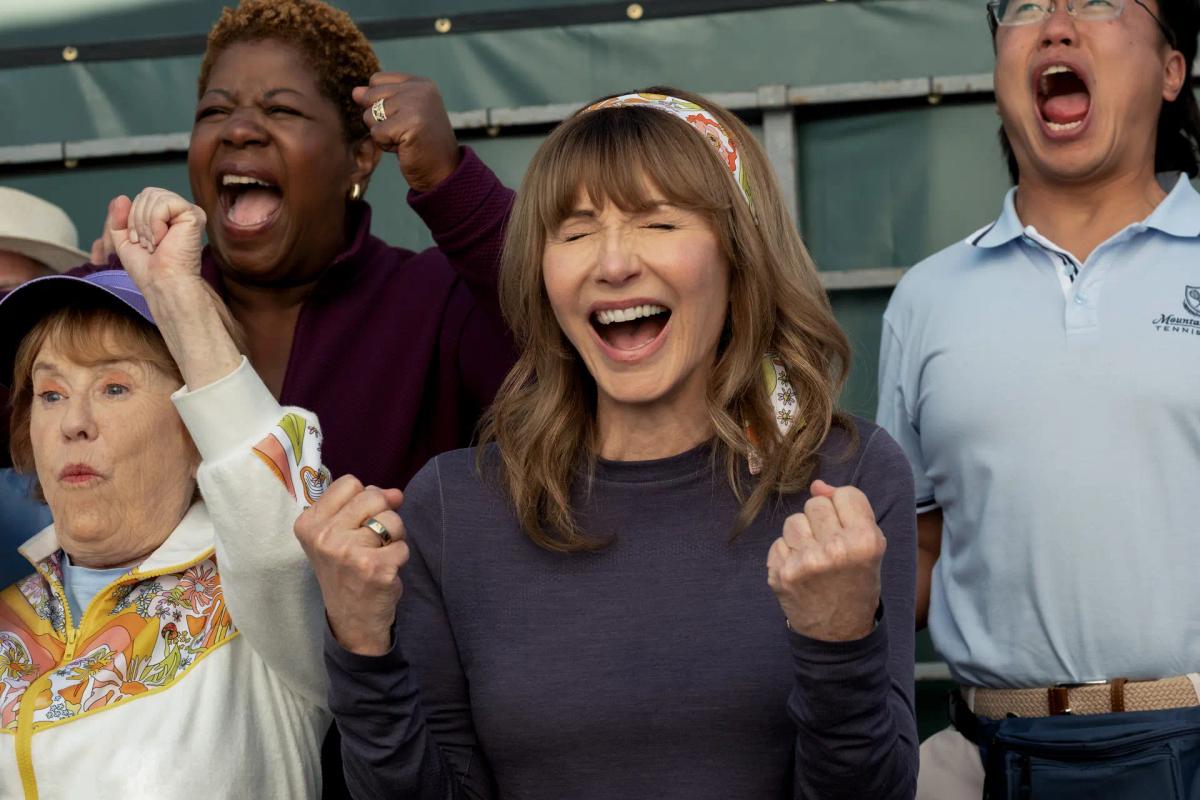 Candace (Mary Steenburgen) cheers with clenched fists among the club's pickleball players, with PJ (Aaron Chen) shouting behind her.