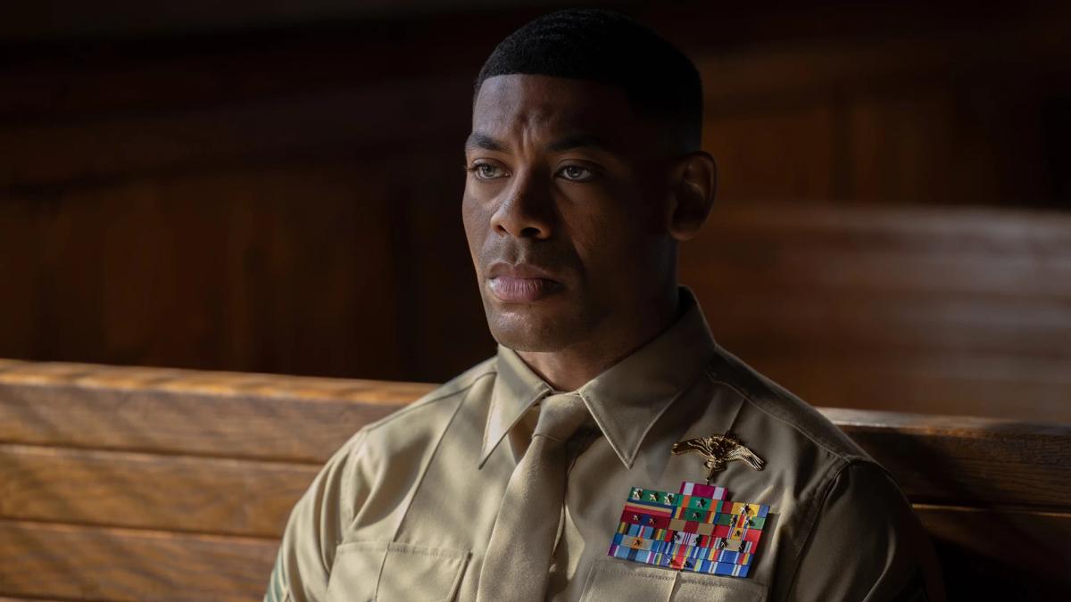 Aaron Pierre as John Stewart in Marine dress uniform, seated and looking off to one side.