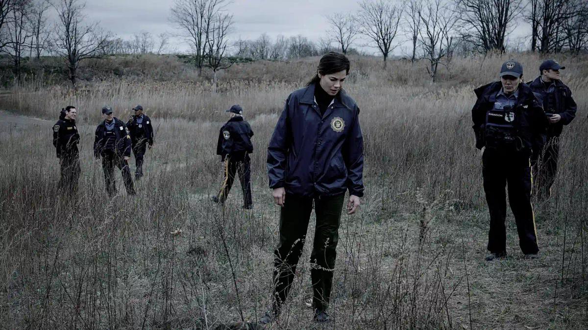 Michelle Monaghan as Detective Amanda Beck leading a line of officers across a bare winter field in The Whisper Man.