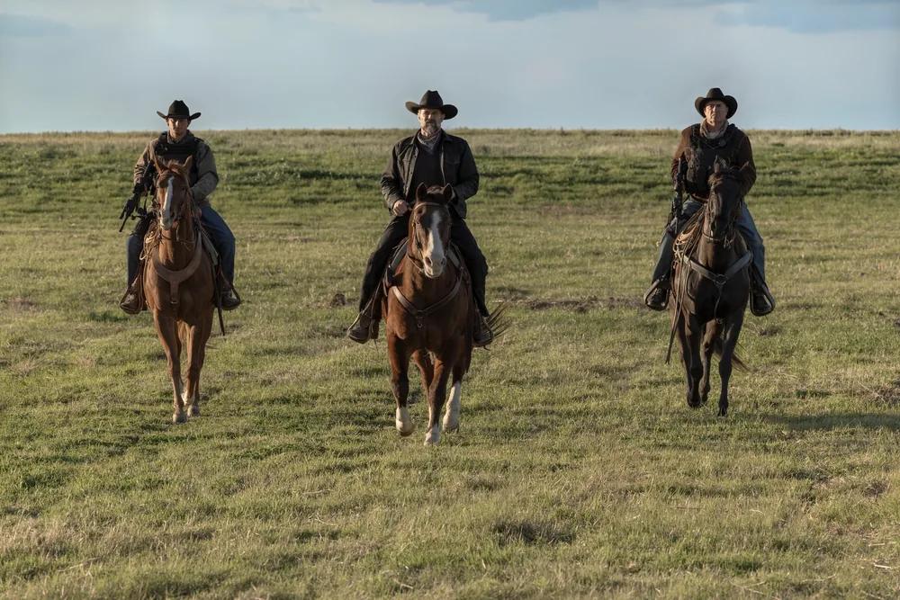 Garret Dillahunt as William Macon riding across open ranch land flanked by two armed men on horseback.