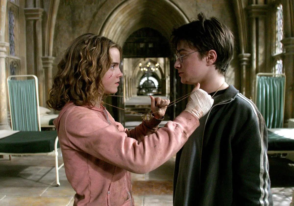 Emma Watson as Hermione Granger looping the Time-Turner chain over Daniel Radcliffe as Harry Potter in the hospital wing.