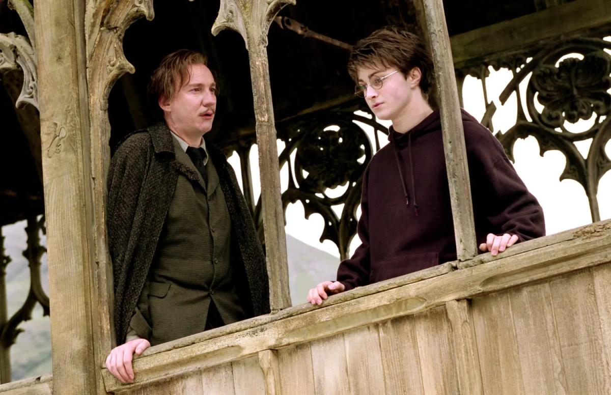 David Thewlis as Remus Lupin speaks with Daniel Radcliffe as Harry Potter on the wooden bridge.