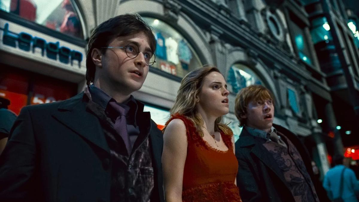 Daniel Radcliffe as Harry Potter, Emma Watson as Hermione Granger and Rupert Grint as Ron Weasley on a London street after escaping the wedding