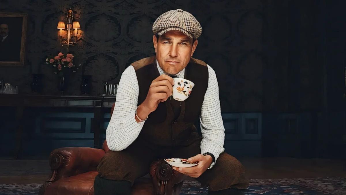 Vinnie Jones as gamekeeper Geoff Seacombe, in a flat cap and waistcoat, drinking from a china teacup.