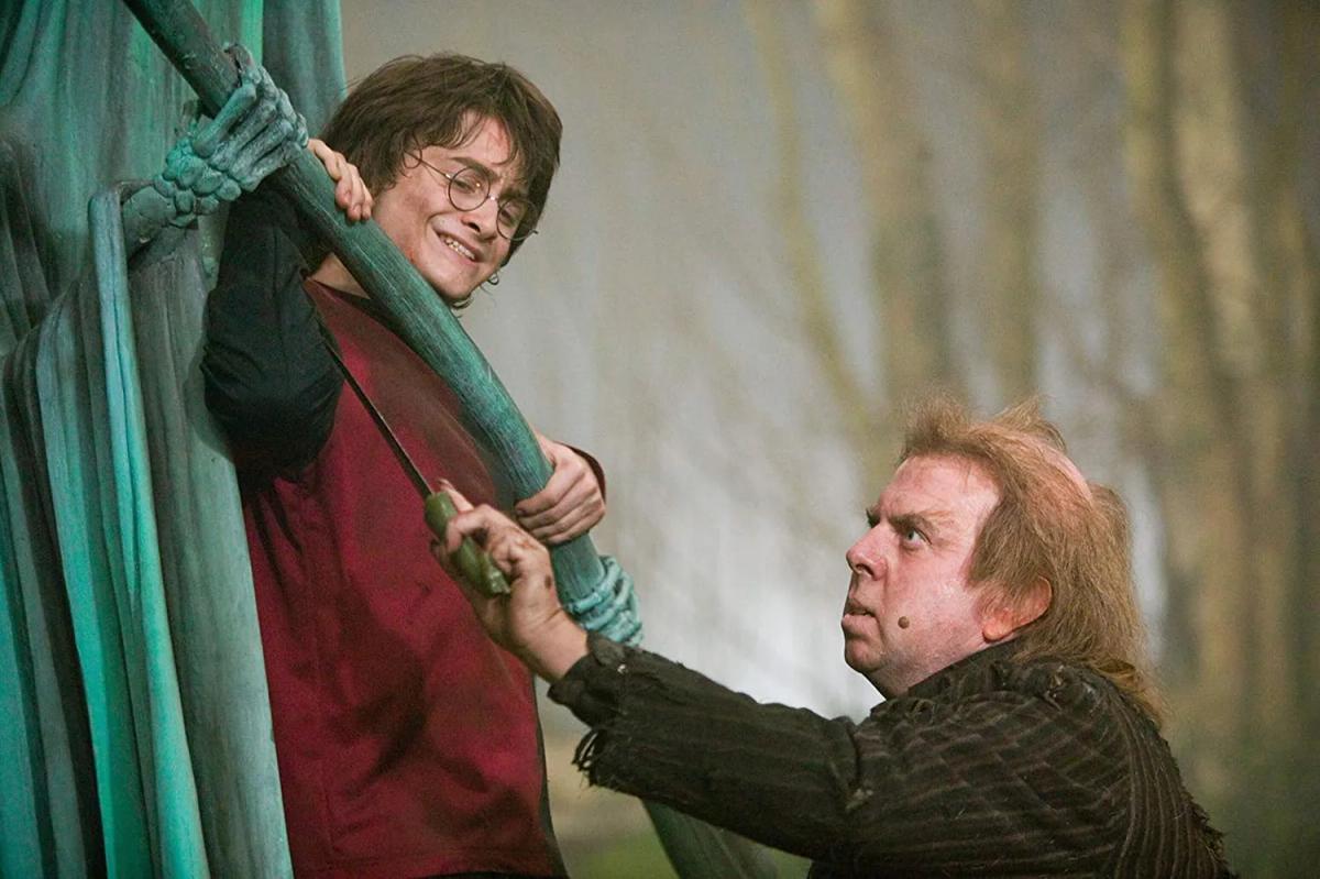 Timothy Spall as Peter Pettigrew takes blood from Daniel Radcliffe as Harry Potter in the graveyard ritual.