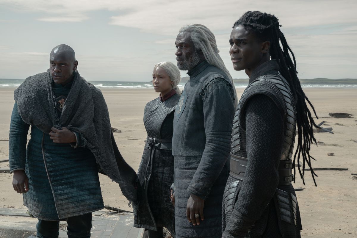 Corlys Velaryon standing on a beach with Baela, Alyn and Addam beside him, all looking out at something off-frame