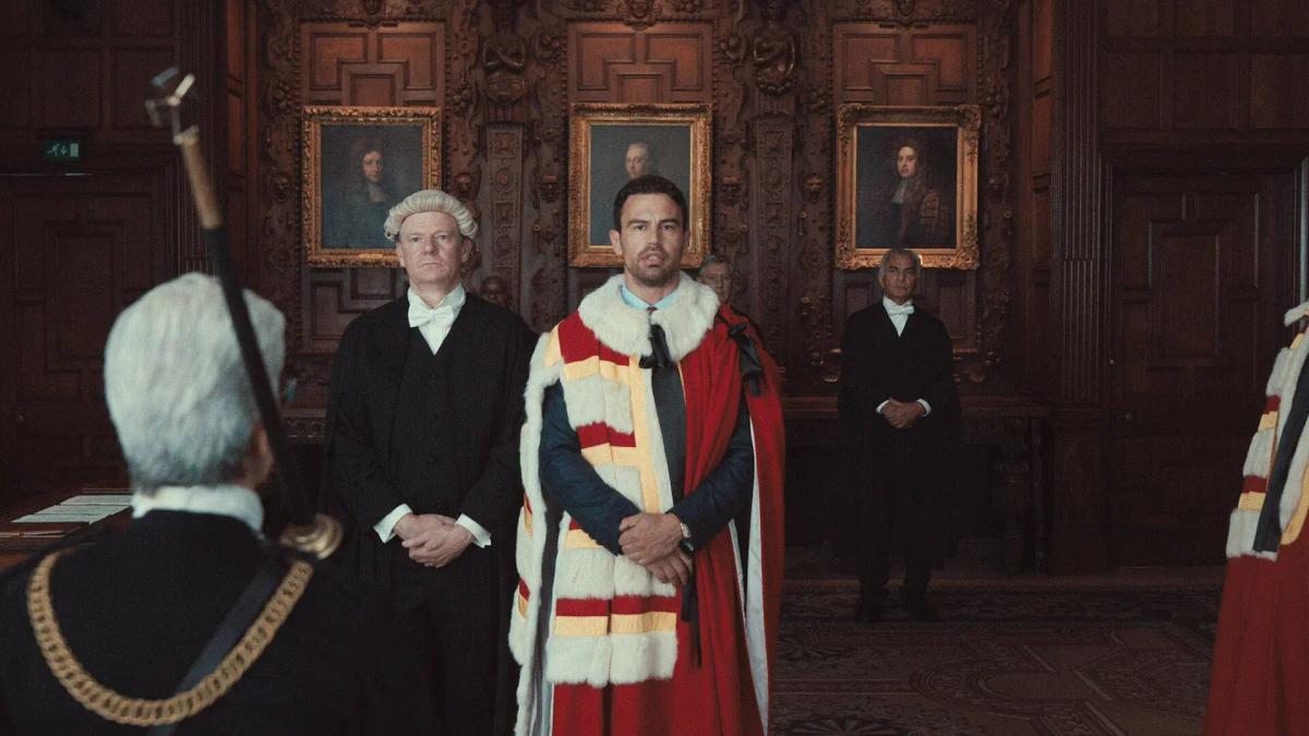 Theo James as Eddie Horniman in the scarlet and ermine robes of a peer, being sworn in to the House of Lords.