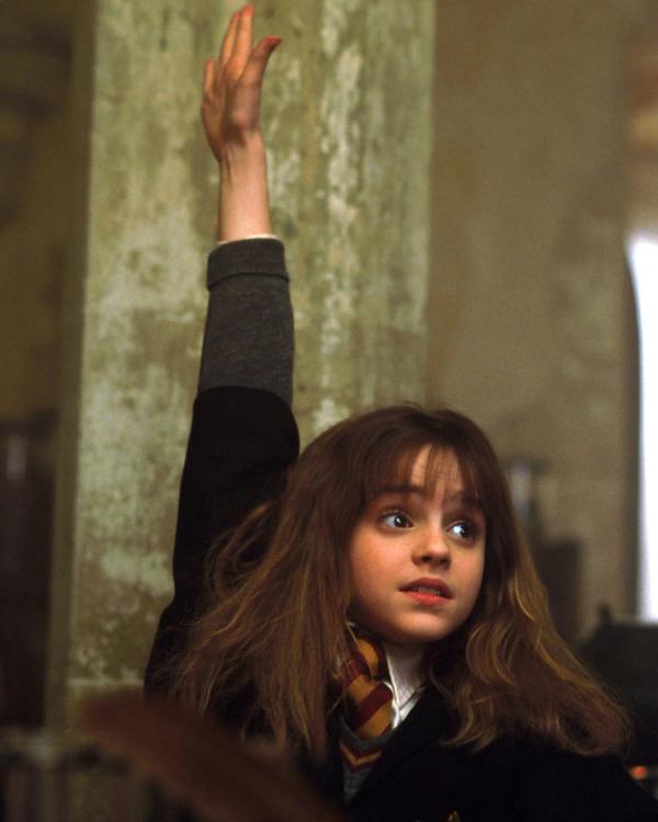 Emma Watson as Hermione Granger raising her hand in the first Potions lesson