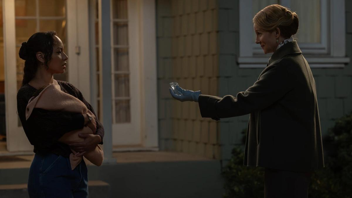 Laura Linney as a Guardian holding out a large diamond to Jasmine Cephas Jones as Bernadette, who is holding her baby, outside their house.