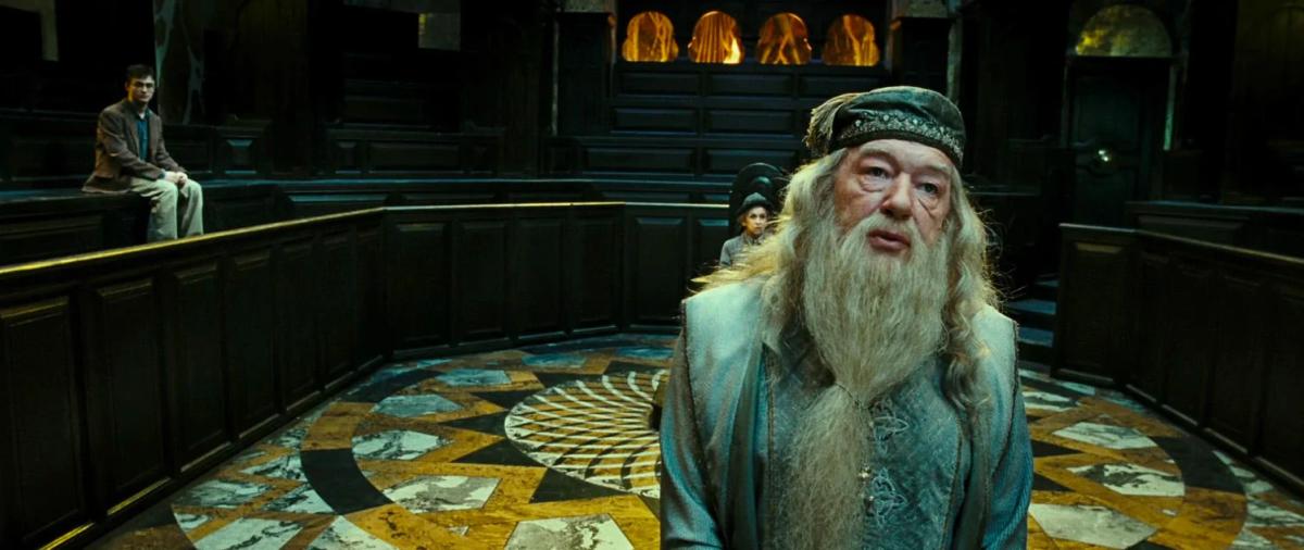 Michael Gambon as Albus Dumbledore in the Ministry courtroom with Daniel Radcliffe as Harry Potter seated behind him