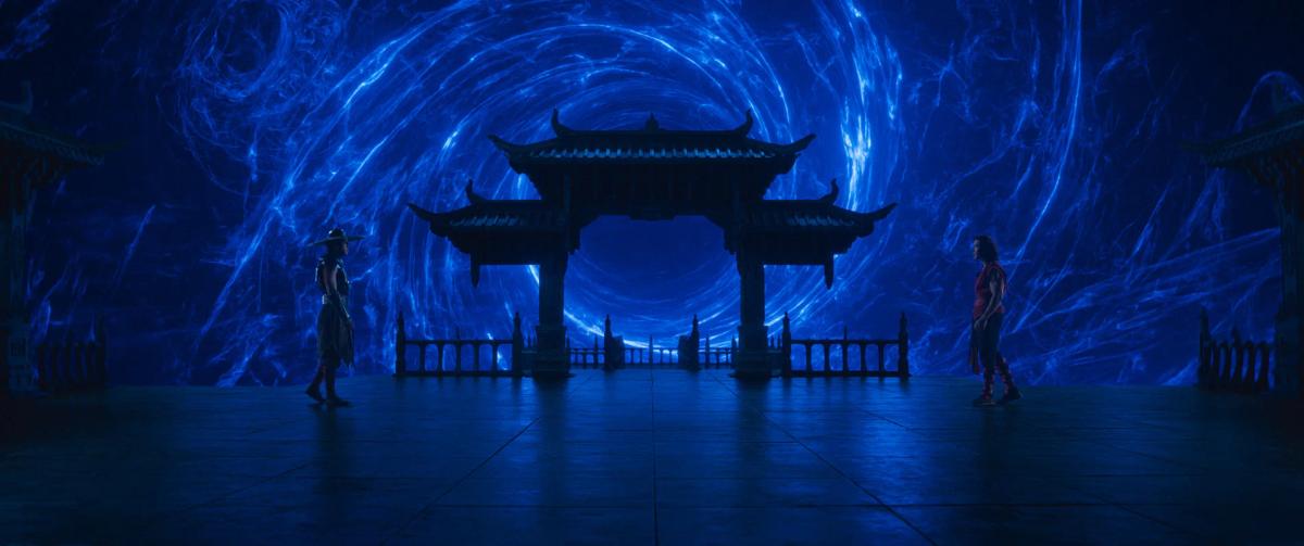 Two fighters face each other on a stone platform beneath a tiered gate, with a swirling blue portal filling the sky behind them.
