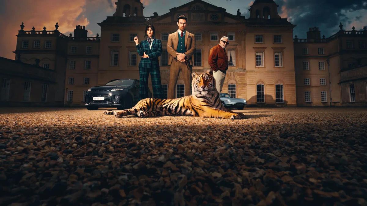 Kaya Scodelario as Susie Glass, Theo James as Eddie Horniman and Ray Winstone as Bobby Glass standing outside Halstead Manor at dusk behind a full-grown tiger lying on the gravel.