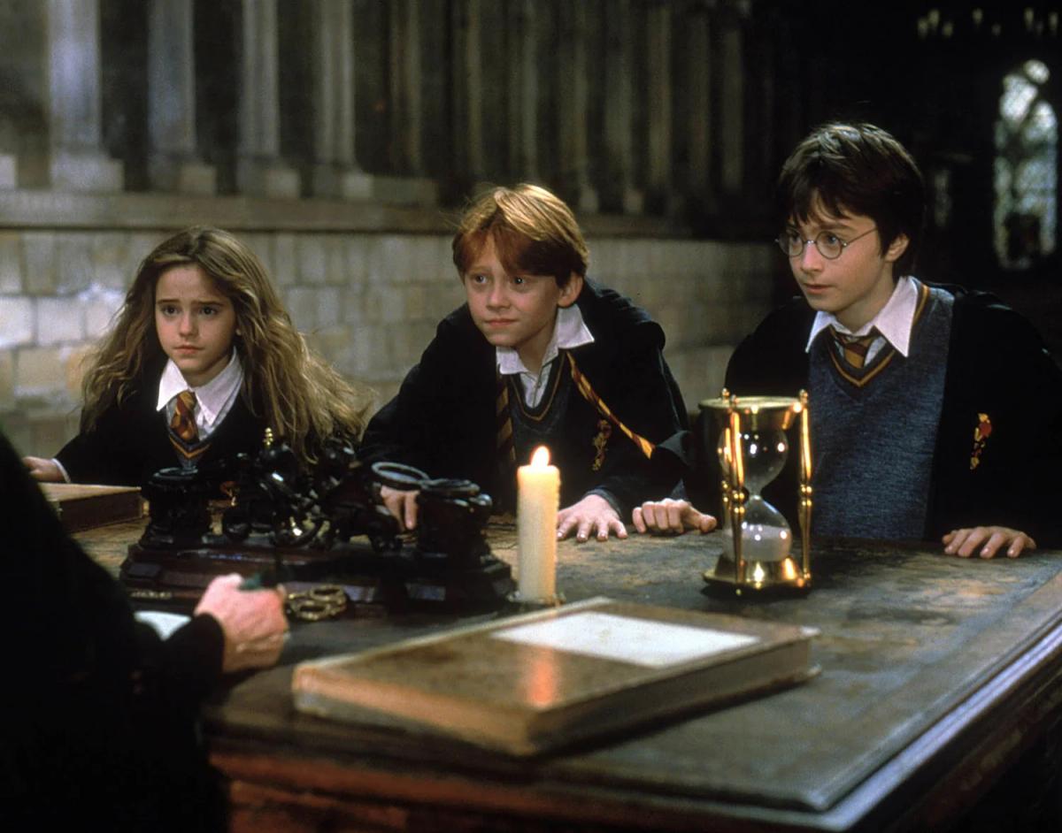 Emma Watson as Hermione Granger, Daniel Radcliffe as Harry Potter and Rupert Grint as Ron Weasley face Maggie Smith as Minerva McGonagall at her desk.