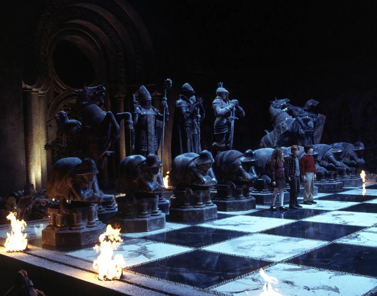 The giant wizard's chess set lit by torches, with stone pieces towering over the players on the board.