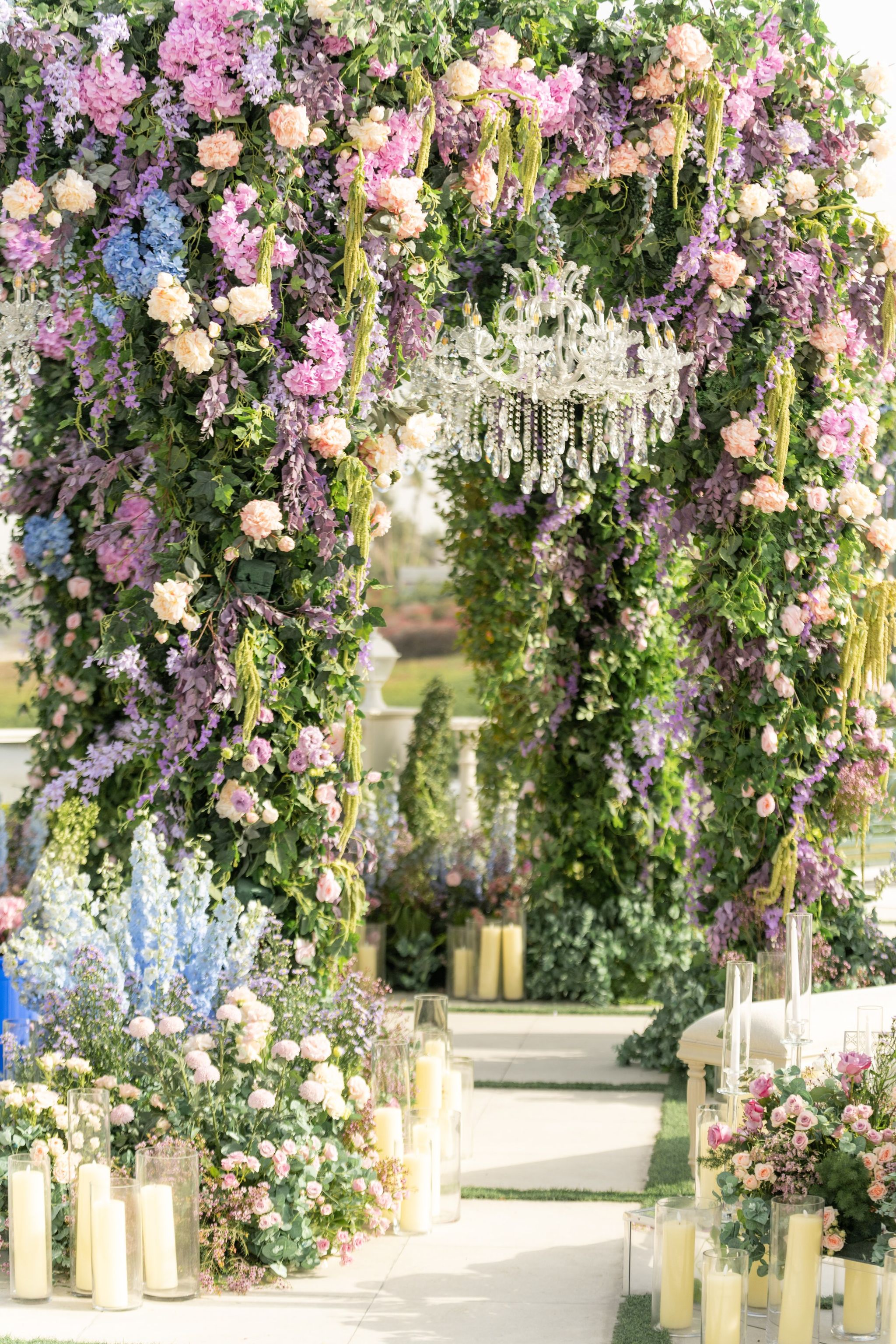 Close view of the canopy's wisteria, garden roses and hanging amaranthus around a crystal chandelier