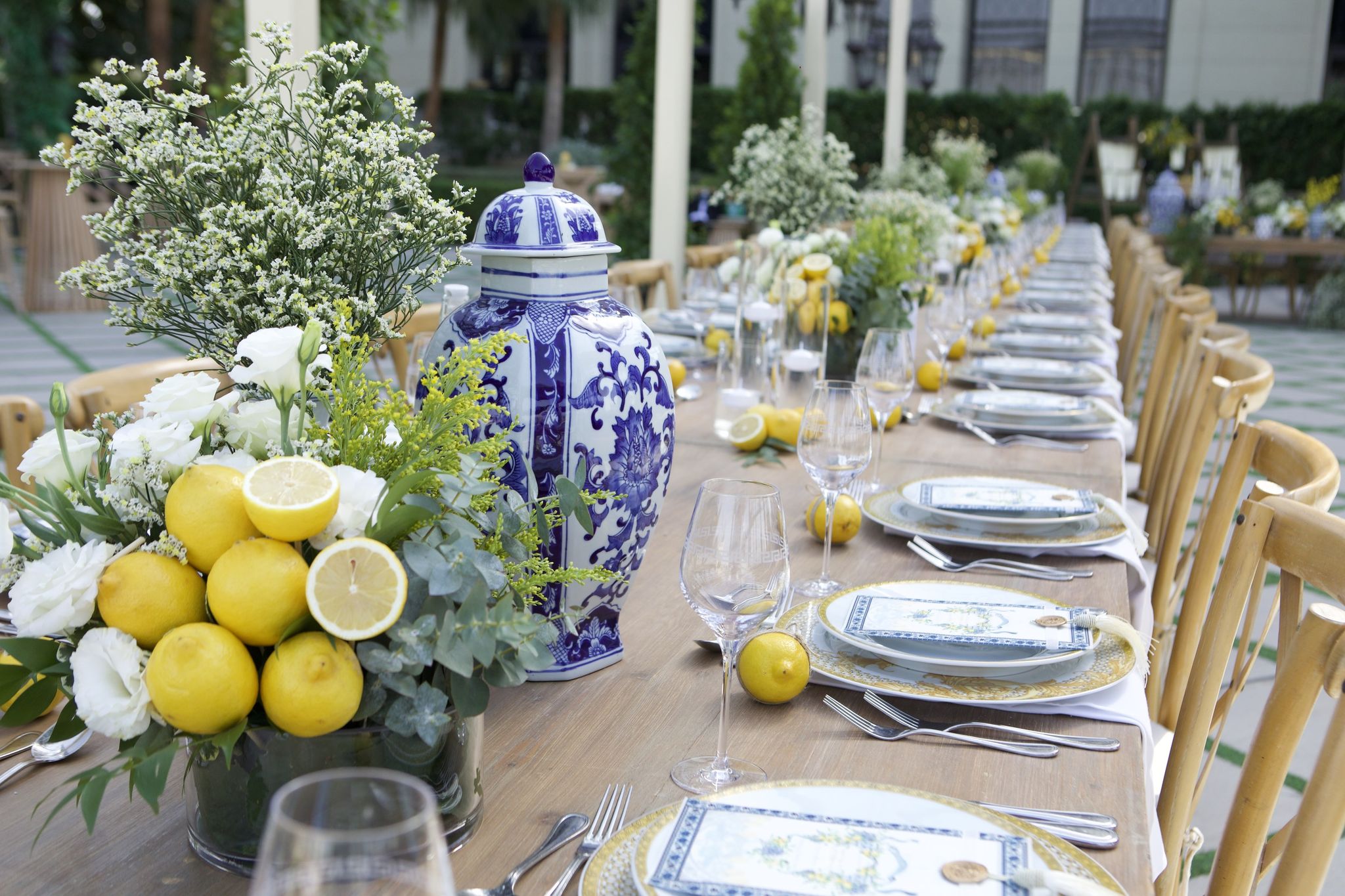 Centrepiece of halved lemons, white roses and mimosa beside a blue-and-white ginger jar at Palazzo Versace Dubai