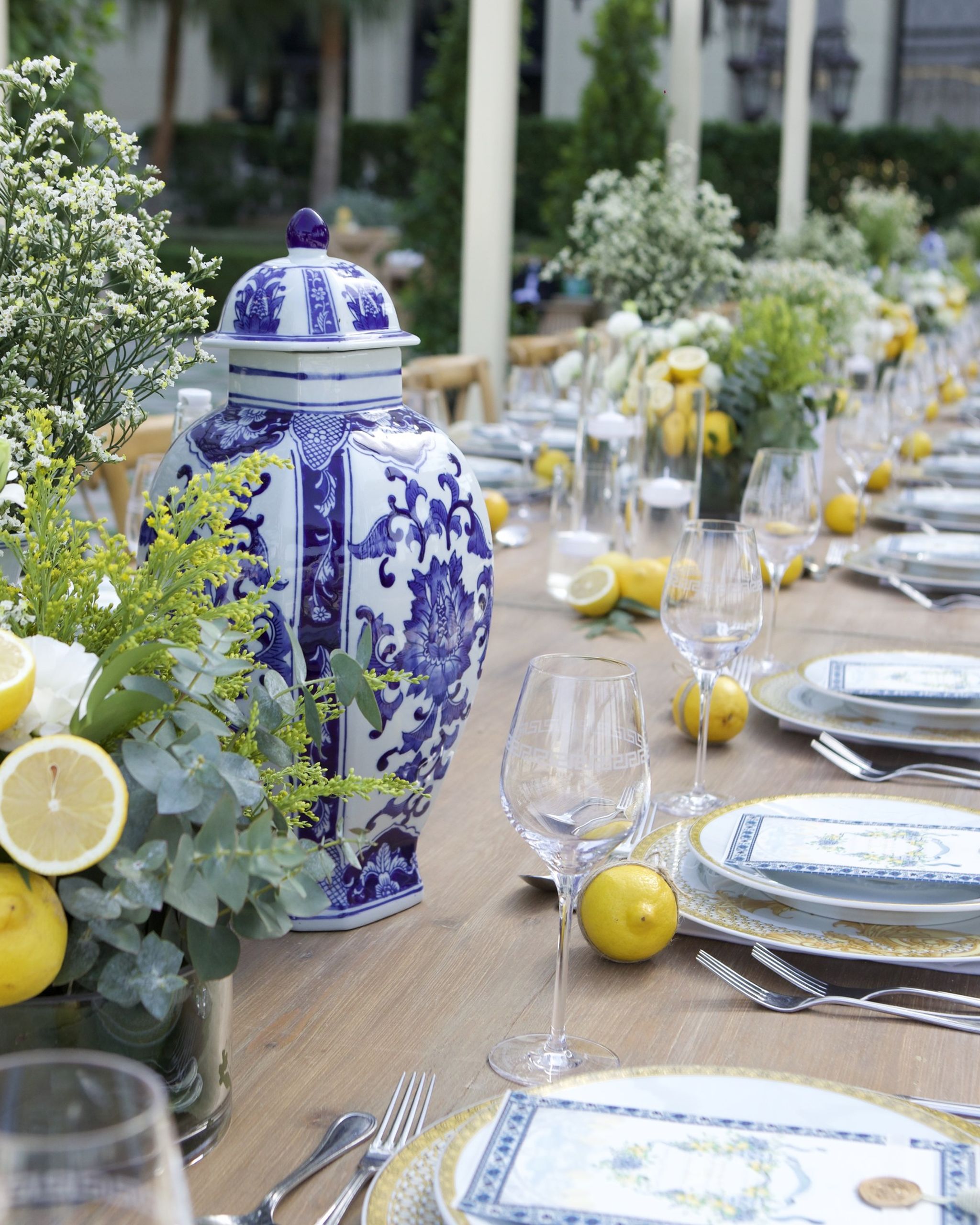 Centrepiece of halved lemons, white roses and mimosa beside a blue-and-white ginger jar at Palazzo Versace Dubai