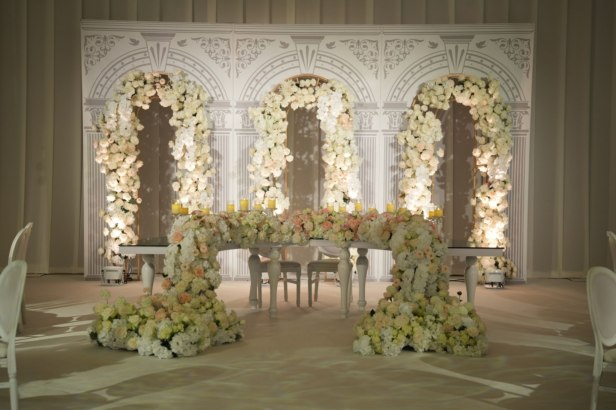 Head table beneath three rose-and-orchid arches in the ballroom at Four Seasons Resort Dubai at Jumeirah Beach