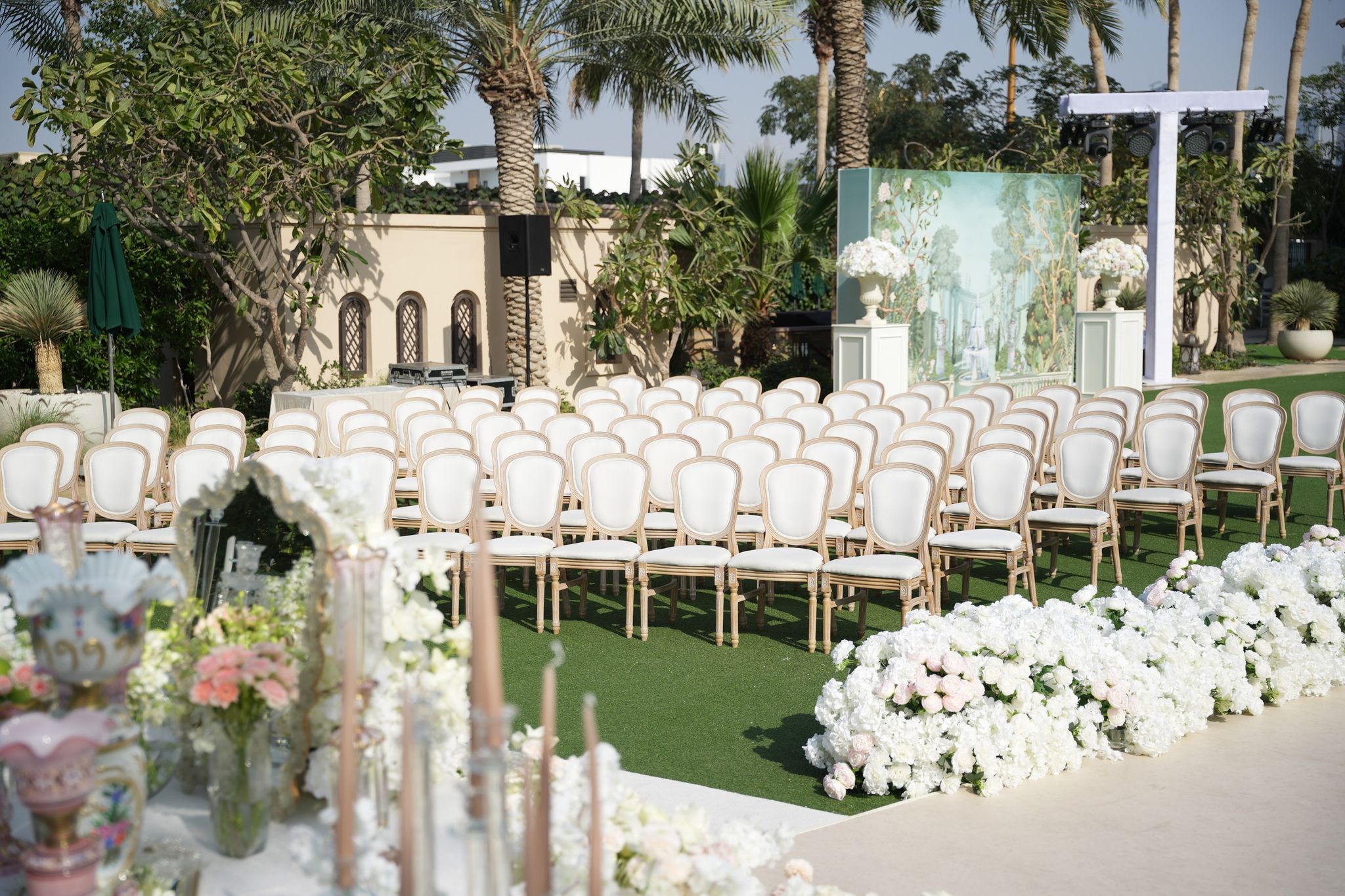 Ivory chairs facing a painted garden backdrop on the lawn at Four Seasons Resort Dubai at Jumeirah Beach