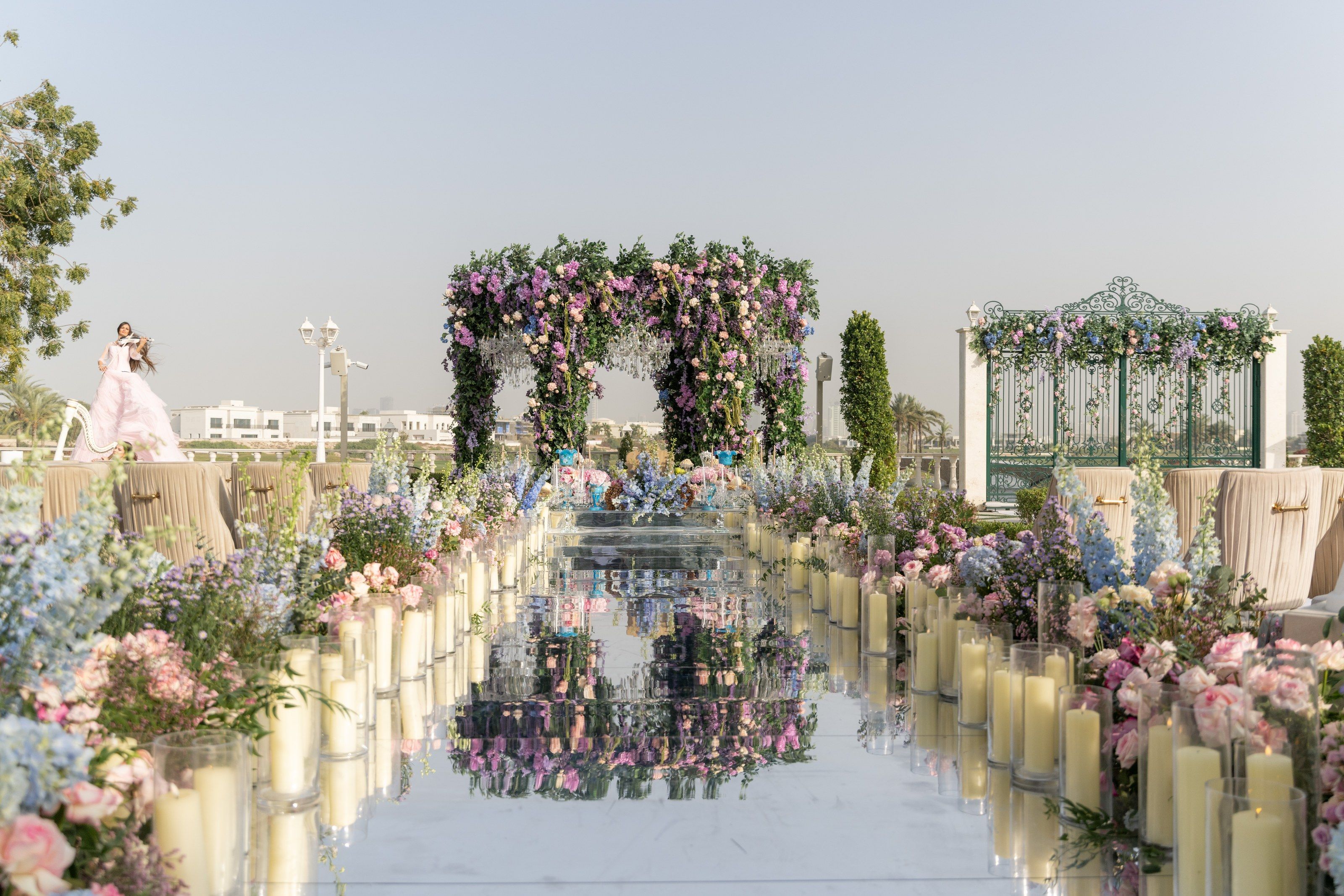 Candlelit mirrored aisle leading to a wisteria canopy at Four Seasons Resort Dubai at Jumeirah Beach