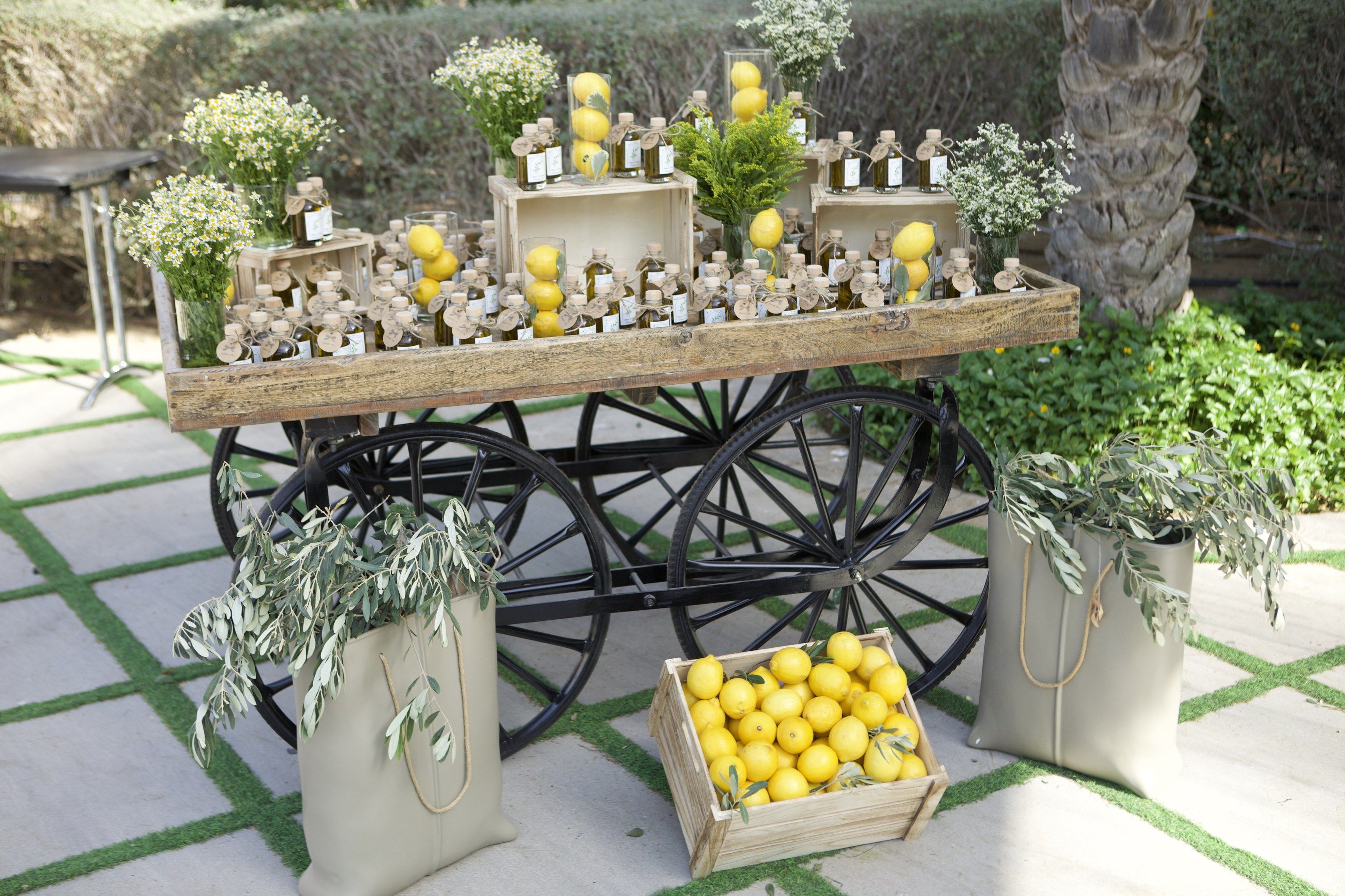 Vintage wooden cart of olive-oil favours and lemons, olive branches in canvas bags, at Palazzo Versace Dubai