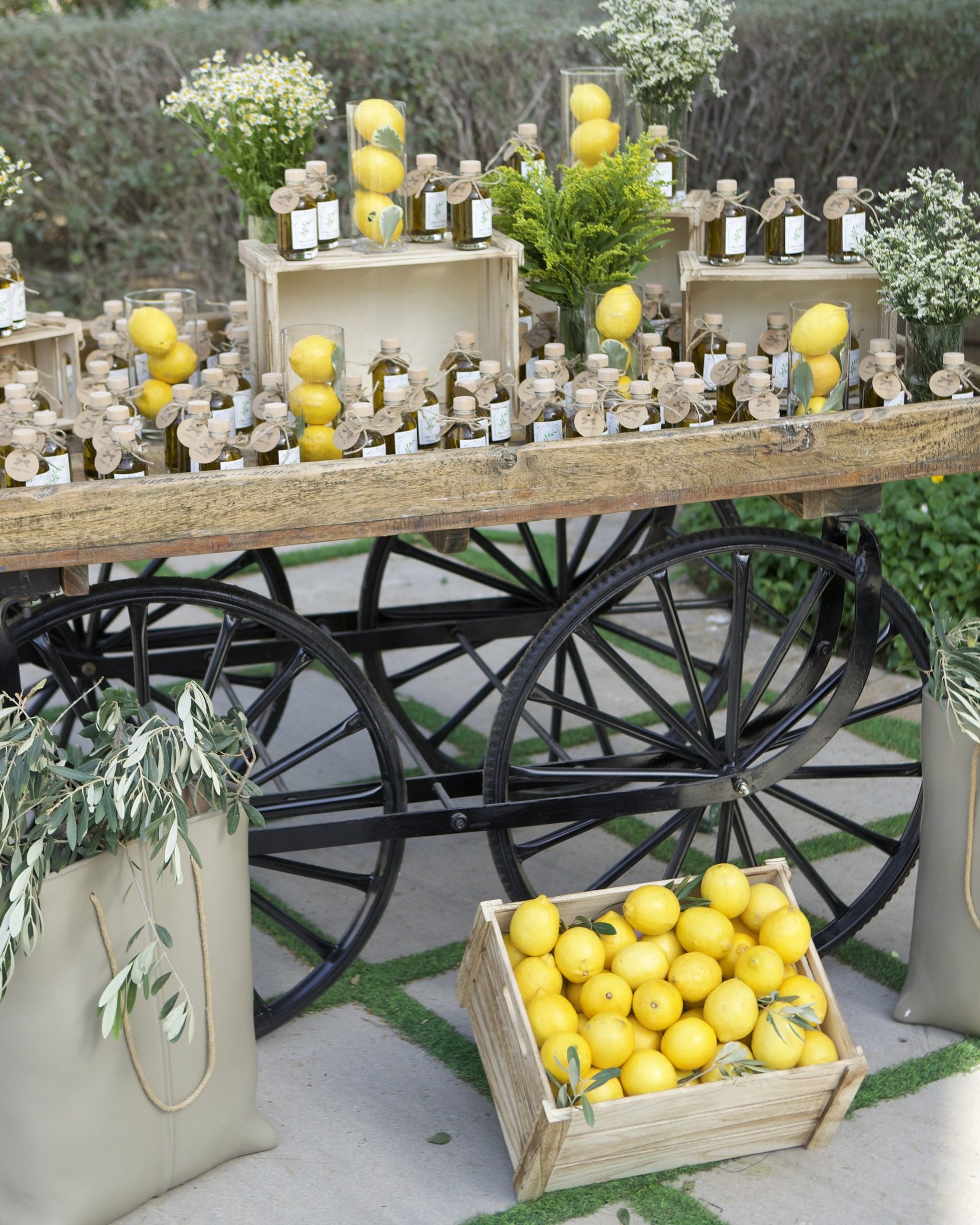 Vintage wooden cart of olive-oil favours and lemons, olive branches in canvas bags, at Palazzo Versace Dubai