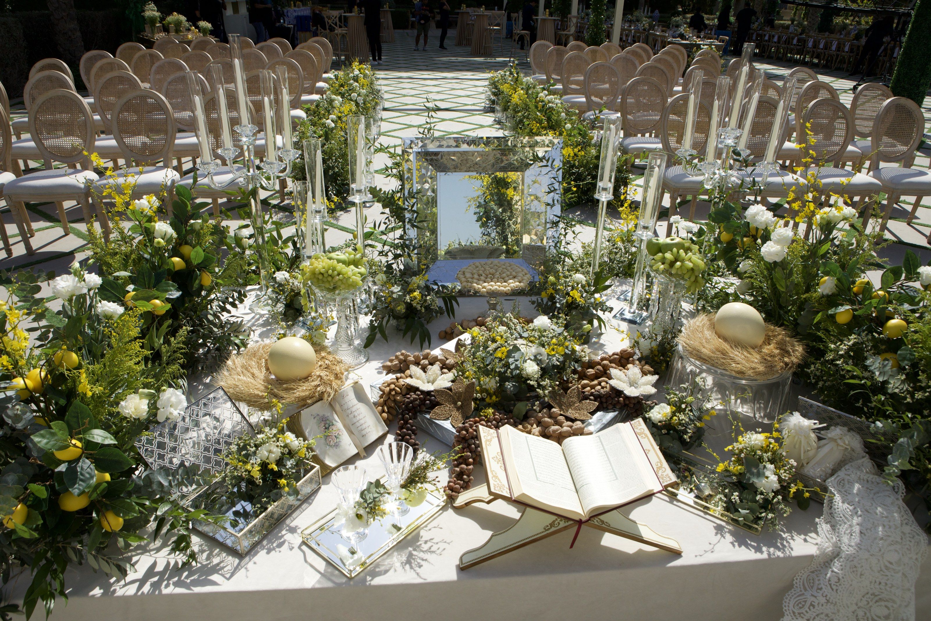 Sofreh aghd with a mirrored panel, open Quran, nests of eggs, nuts and lemons