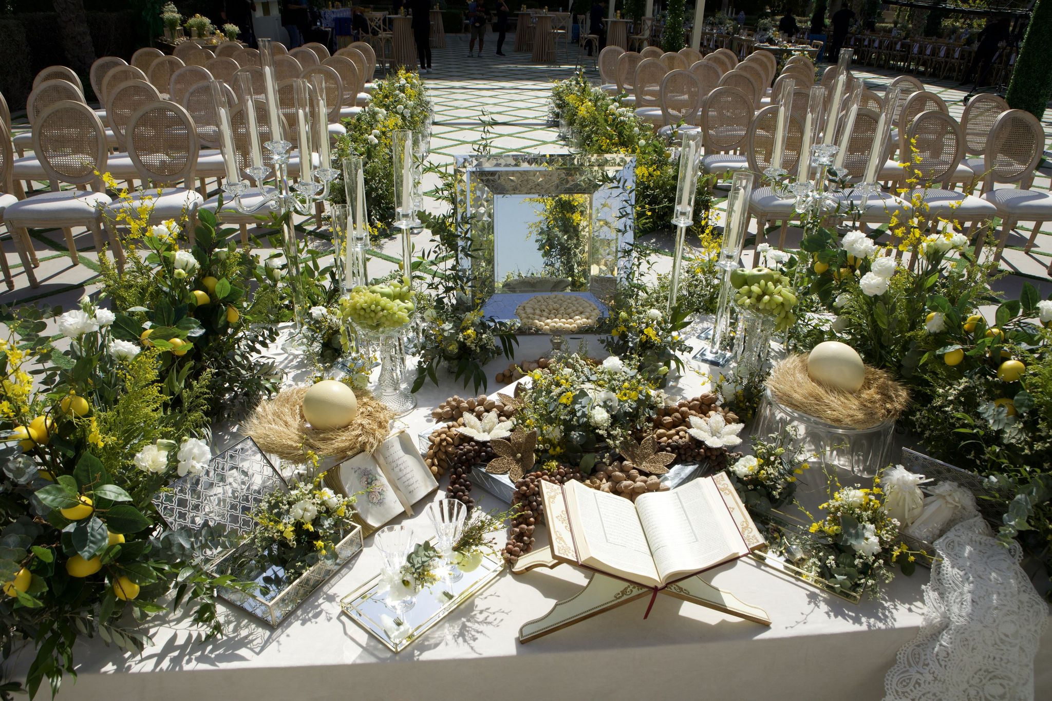 Sofreh aghd with a mirrored panel, open Quran, nests of eggs, nuts and lemons