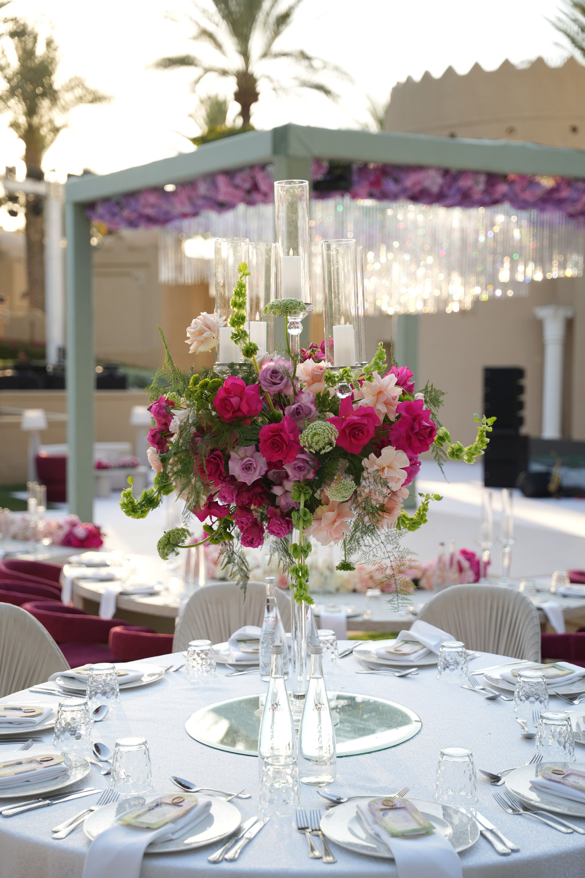 Raised rose and stock centrepiece before a flower-hung pergola with crystal strands at One&Only Royal Mirage Dubai