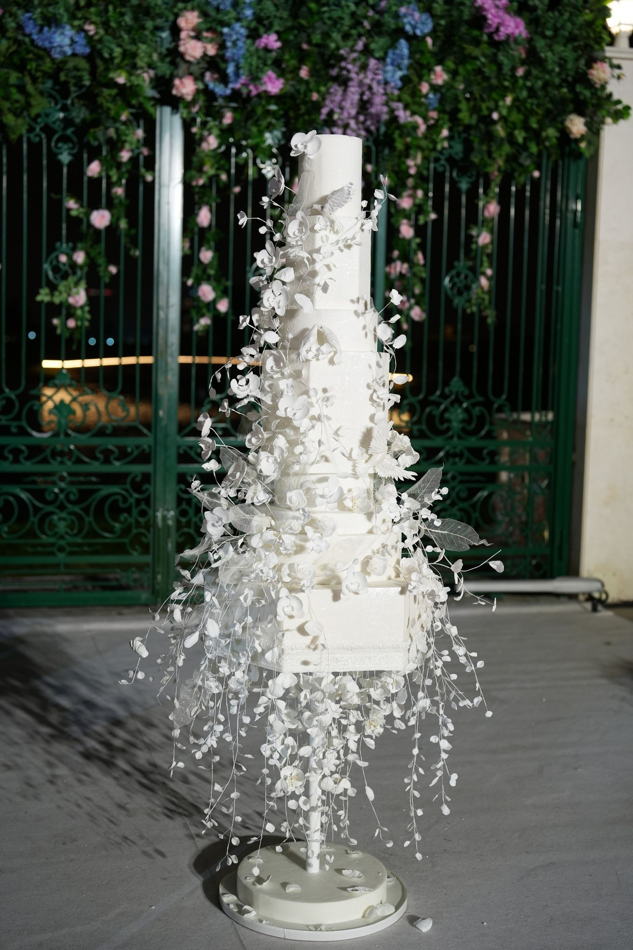 White wedding cake with cascading sugar flowers at night at Four Seasons Resort Dubai at Jumeirah Beach