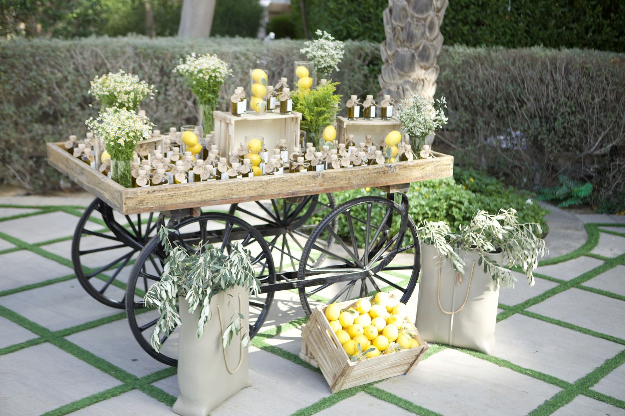 Favour cart of olive-oil bottles and fresh lemons with a crate of lemons below