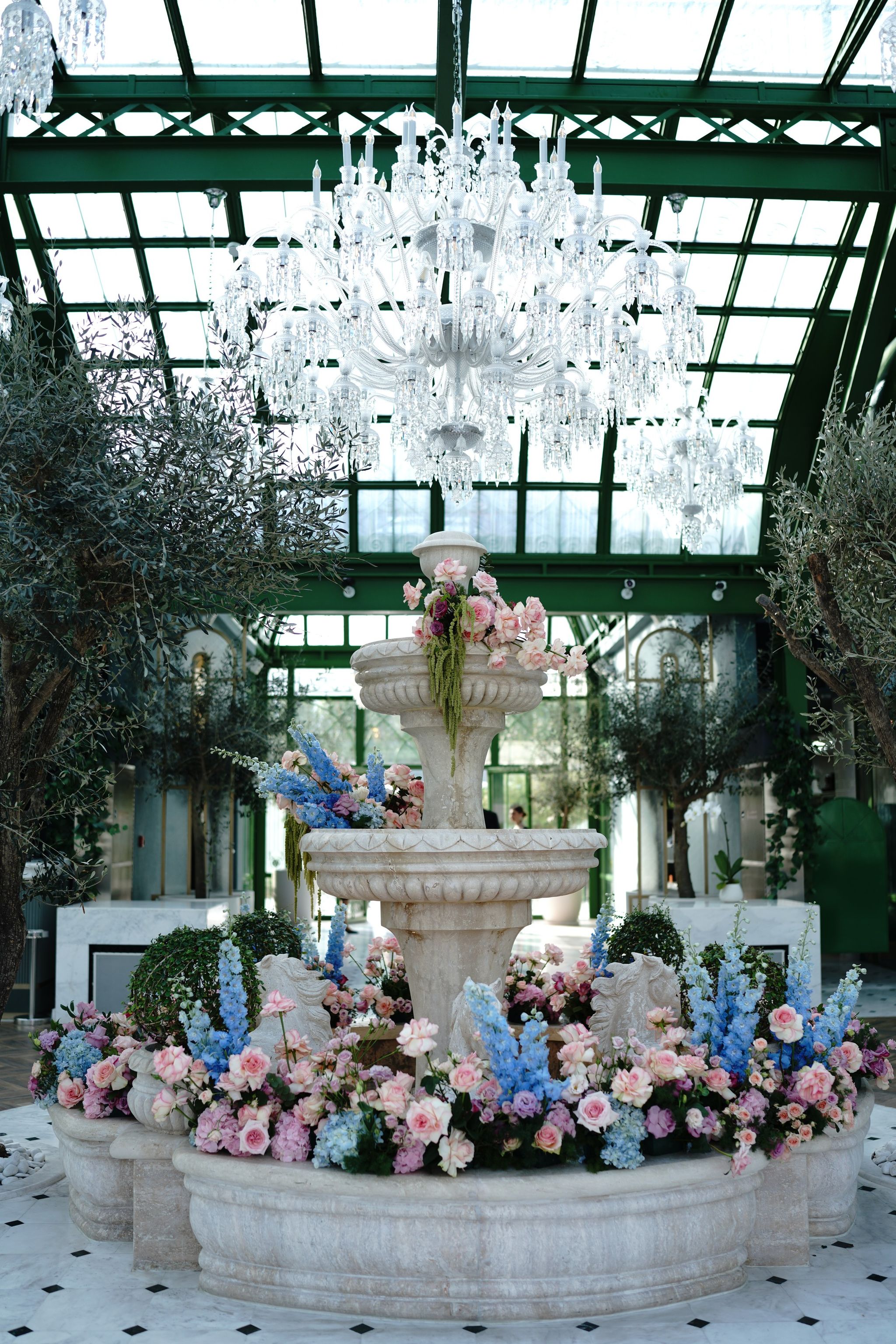 Chandelier above a flower-ringed stone fountain in the conservatory at Four Seasons Resort Dubai at Jumeirah Beach