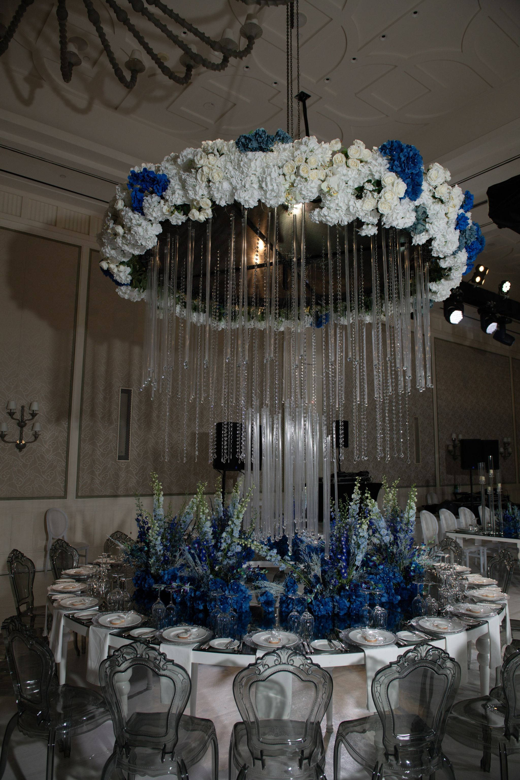 Hydrangea and rose ring trailing crystal strands over a delphinium centrepiece on a round table