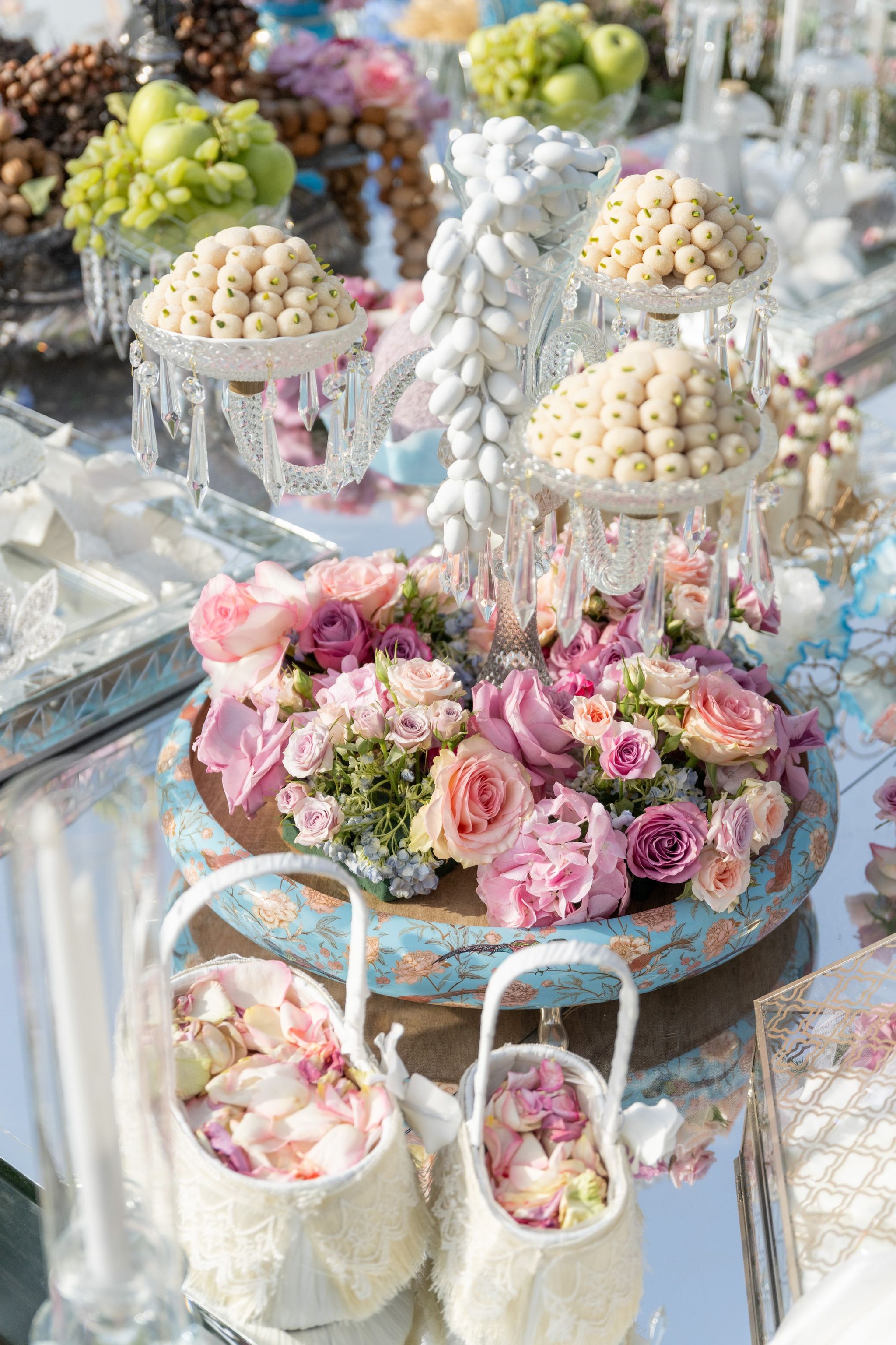 Sugared almonds on crystal stands above a bowl of roses at Four Seasons Resort Dubai at Jumeirah Beach