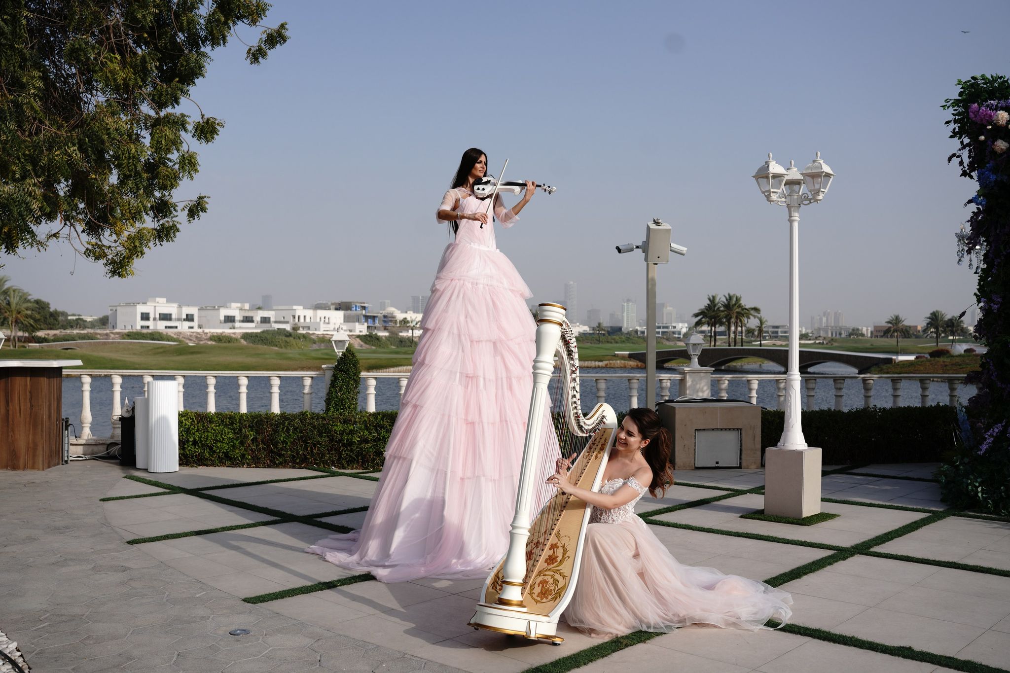 Stilt violinist in pink beside a harpist on the terrace at Four Seasons Resort Dubai at Jumeirah Beach